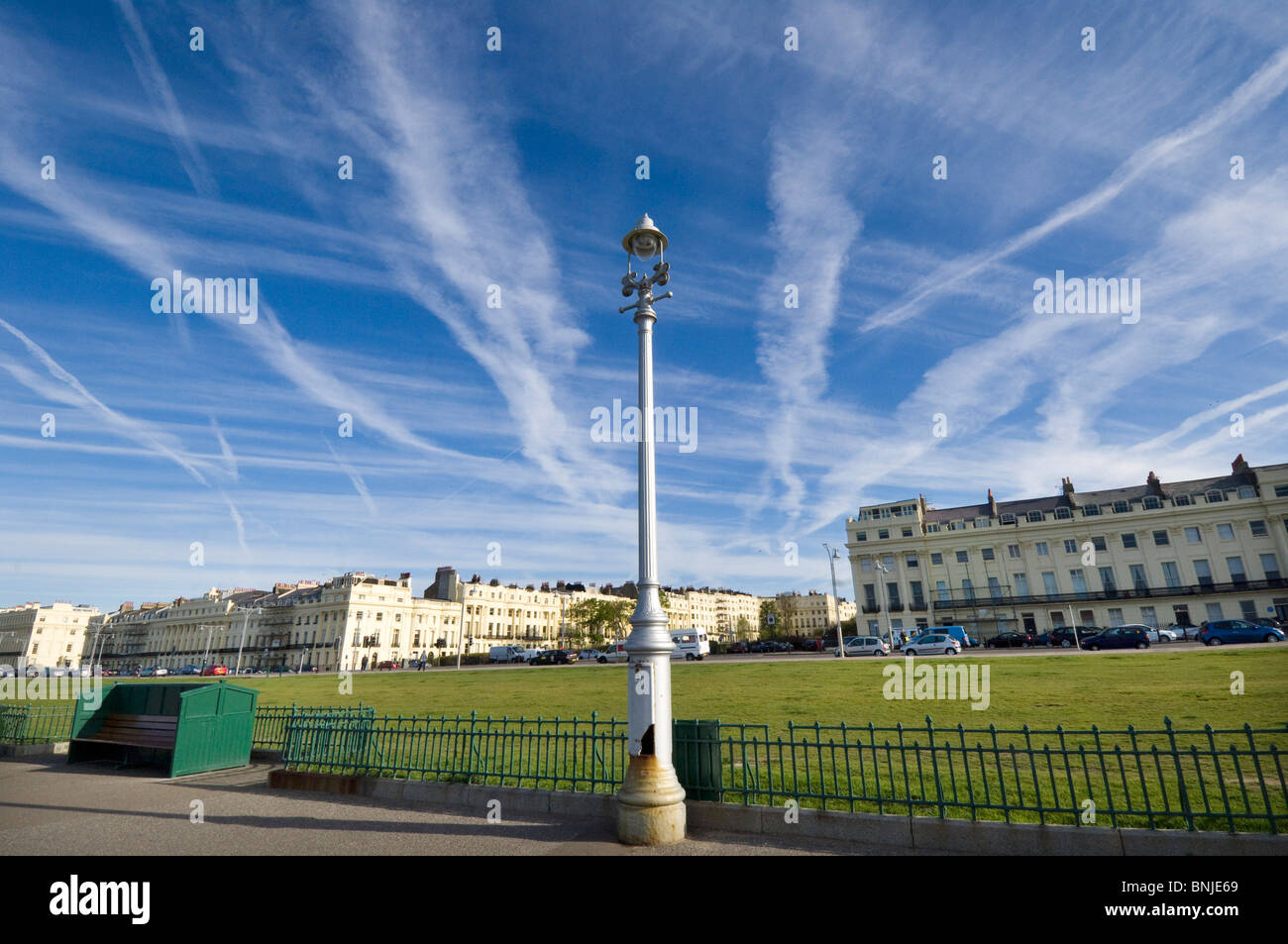 Jet streaks and Jet streams from planes fill the skies above Brunswick Terrace and Brunswick Square at Hove lawns in Sussex Stock Photo