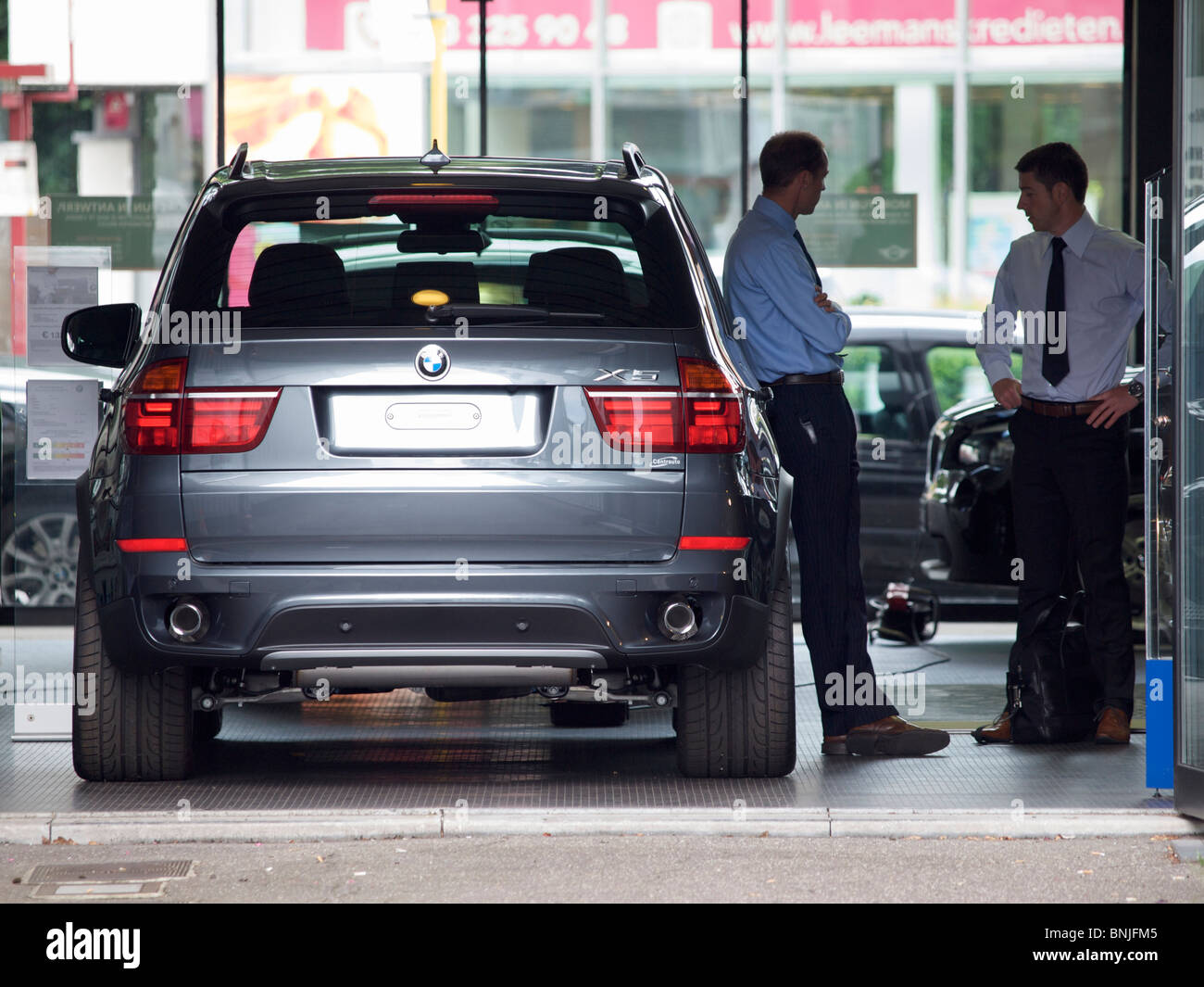 New BMW X5 in car dealer showroom with 2 people talking Antwerp Belgium Stock Photo