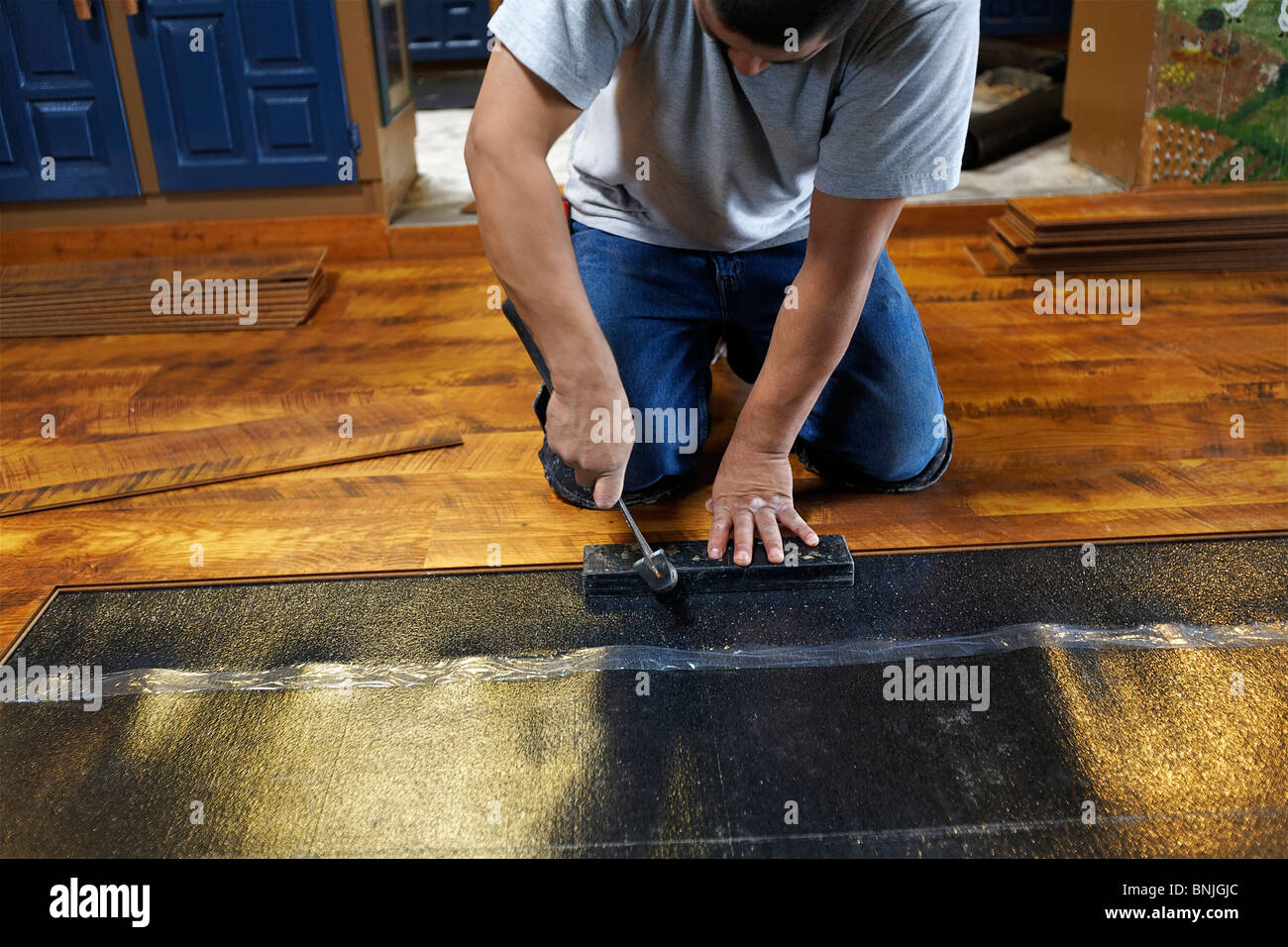 laying new laminate floor flooring worker workers man men indoor indoors houses apartment Stock Photo