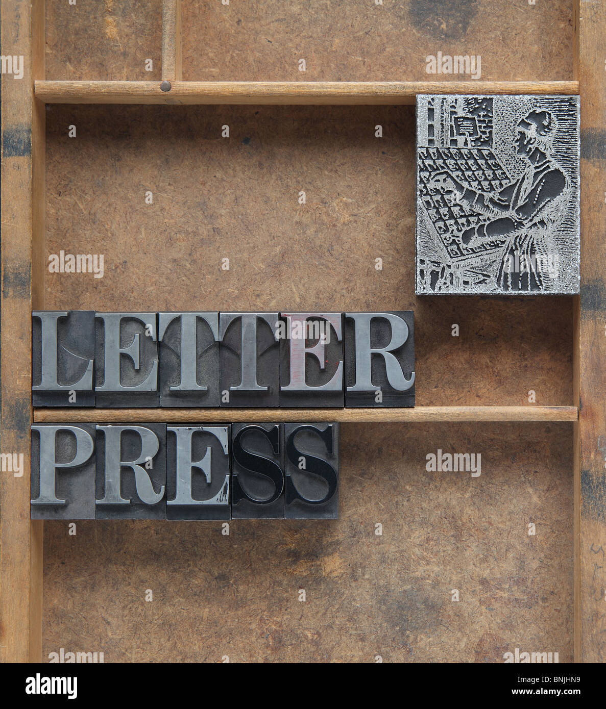 the word letterpress in old lead type with a printer's cut of a typesetter Stock Photo