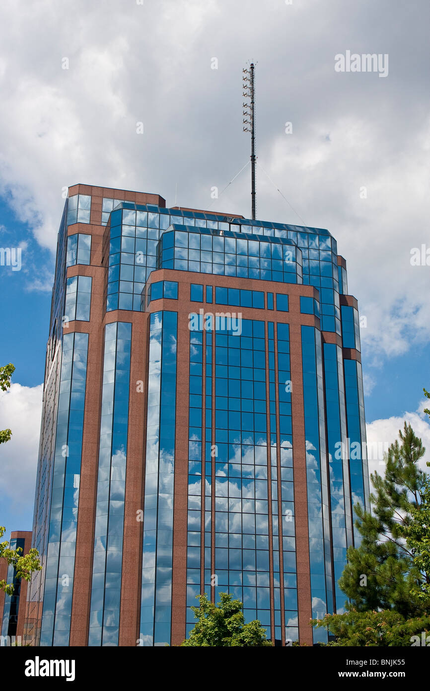 A red brick and blue glass office tower reflecting blue sky Stock Photo ...