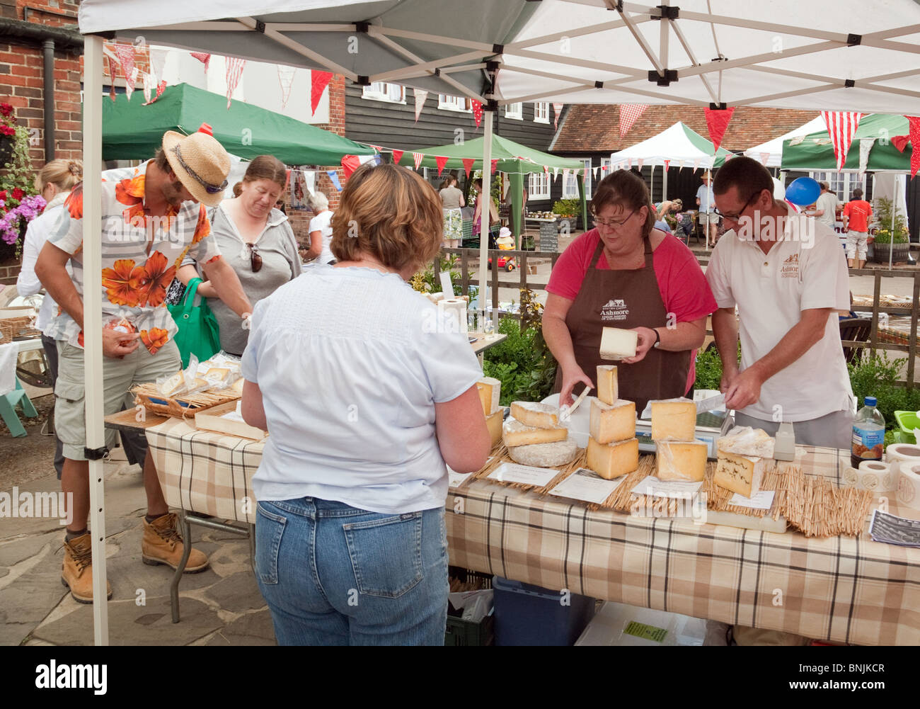 People buying cheese at the cheese stall, the french farmers market in