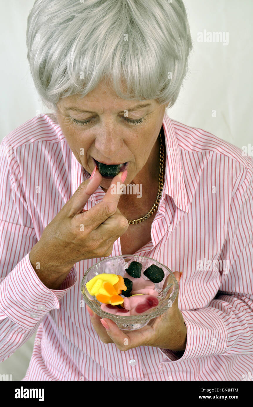 Woman Old Sweets candy candies food eating pensioner mature Stock Photo