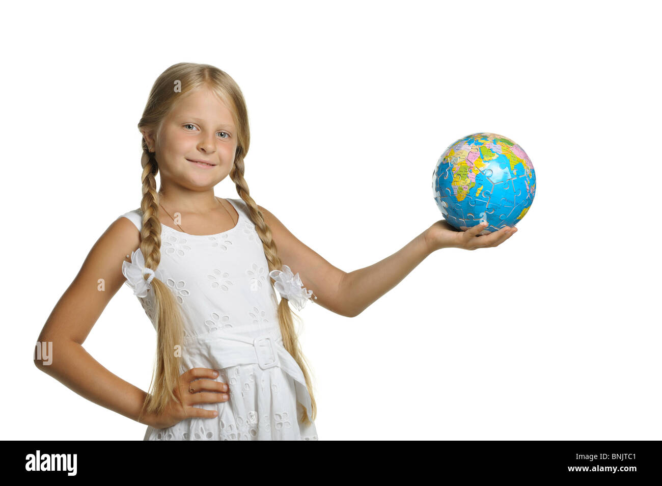 The girl holds the globe collected from puzzle in hands. It is isolated on a white background Stock Photo