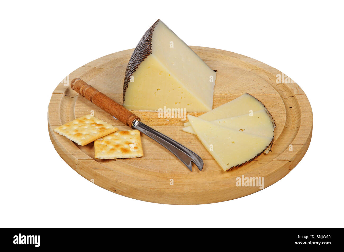 Manchego cheese and crackers on cheese board. Stock Photo