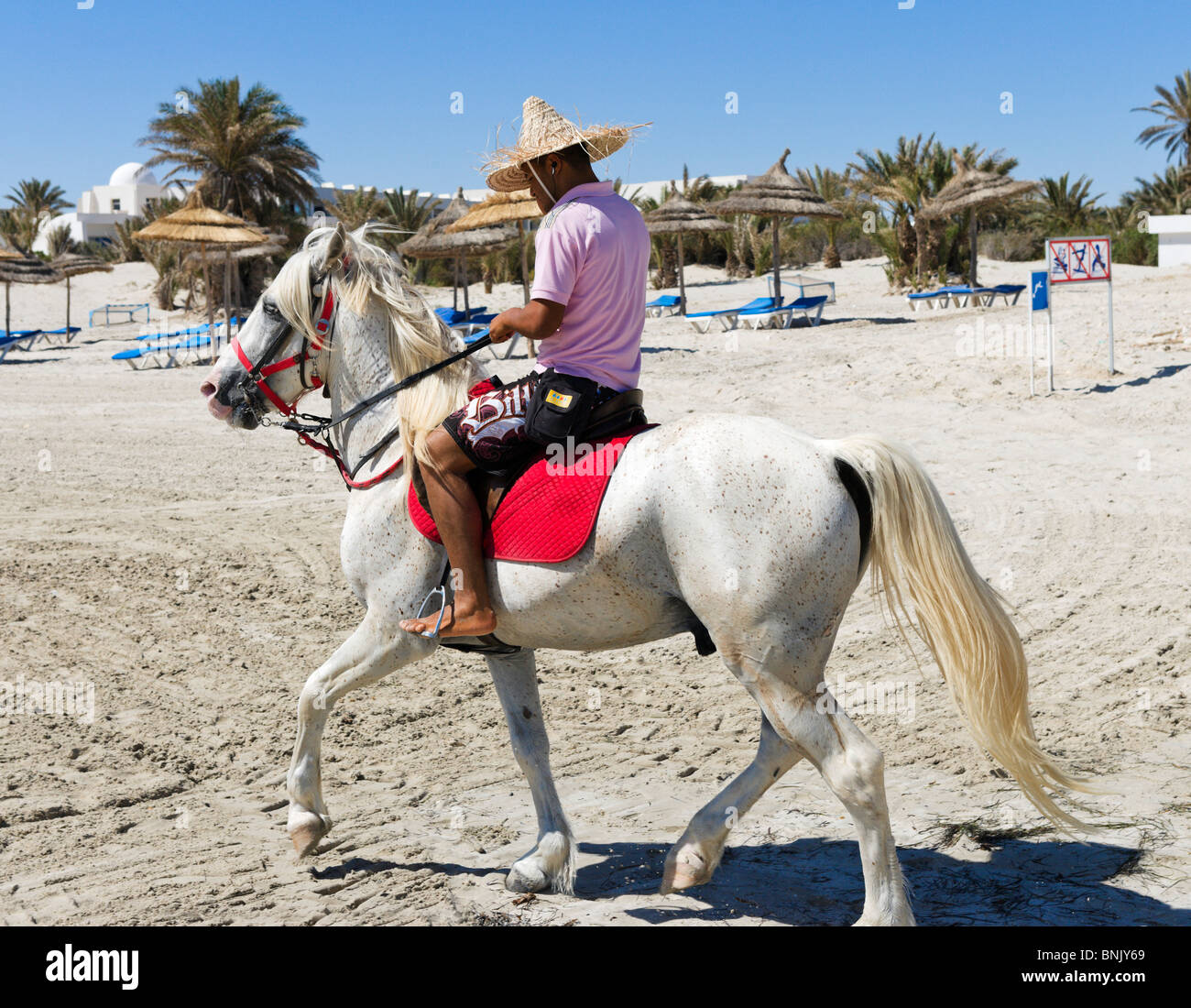 Horseback riding on the beach in the hotel zone, Aghir, Djerba, Tunisia Stock Photo