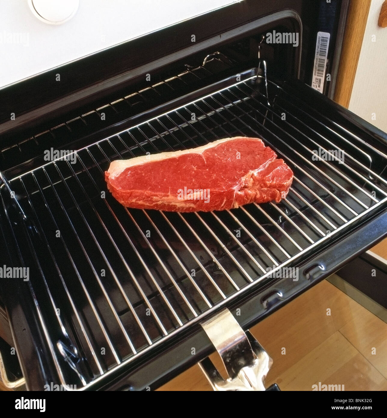 https://c8.alamy.com/comp/BNK32G/raw-sirloin-steak-on-a-grill-pan-being-placed-under-an-oven-grill-BNK32G.jpg