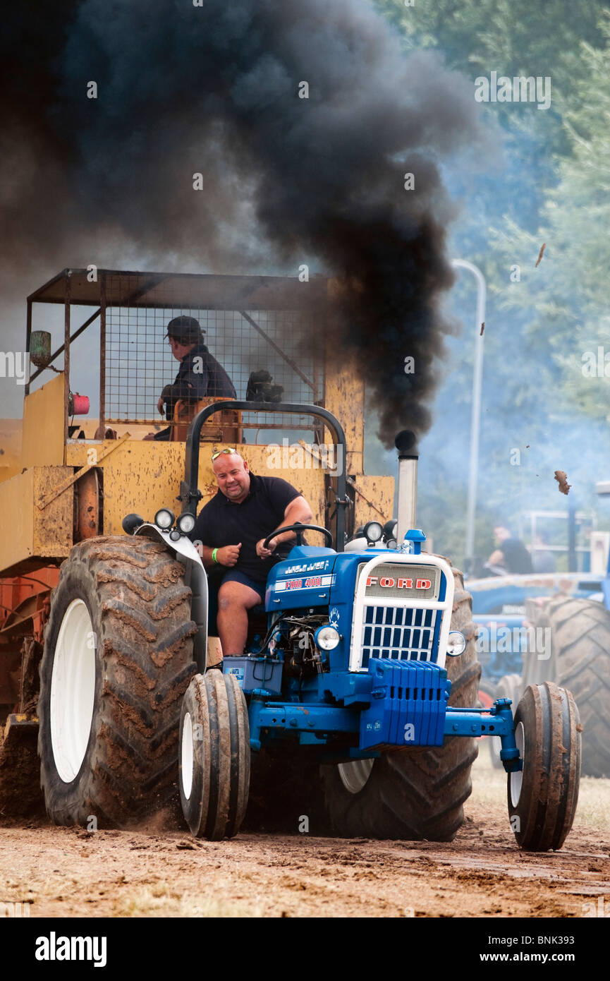 Tractor pulling sport with a weighted sledge at Welland 2010 Steam Rally & Show, UK. Black exhaust smoke tractor pull front view Stock Photo