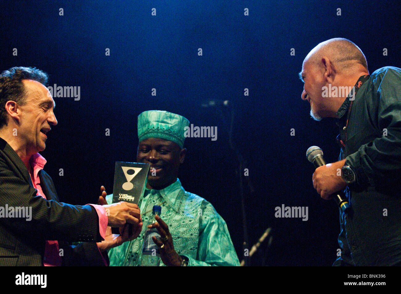 Peter Gabriel presenting Songlines music award for cross-cultural collaboration to Justin Adams and Juldeh Camara, WOMAD 2010 Stock Photo