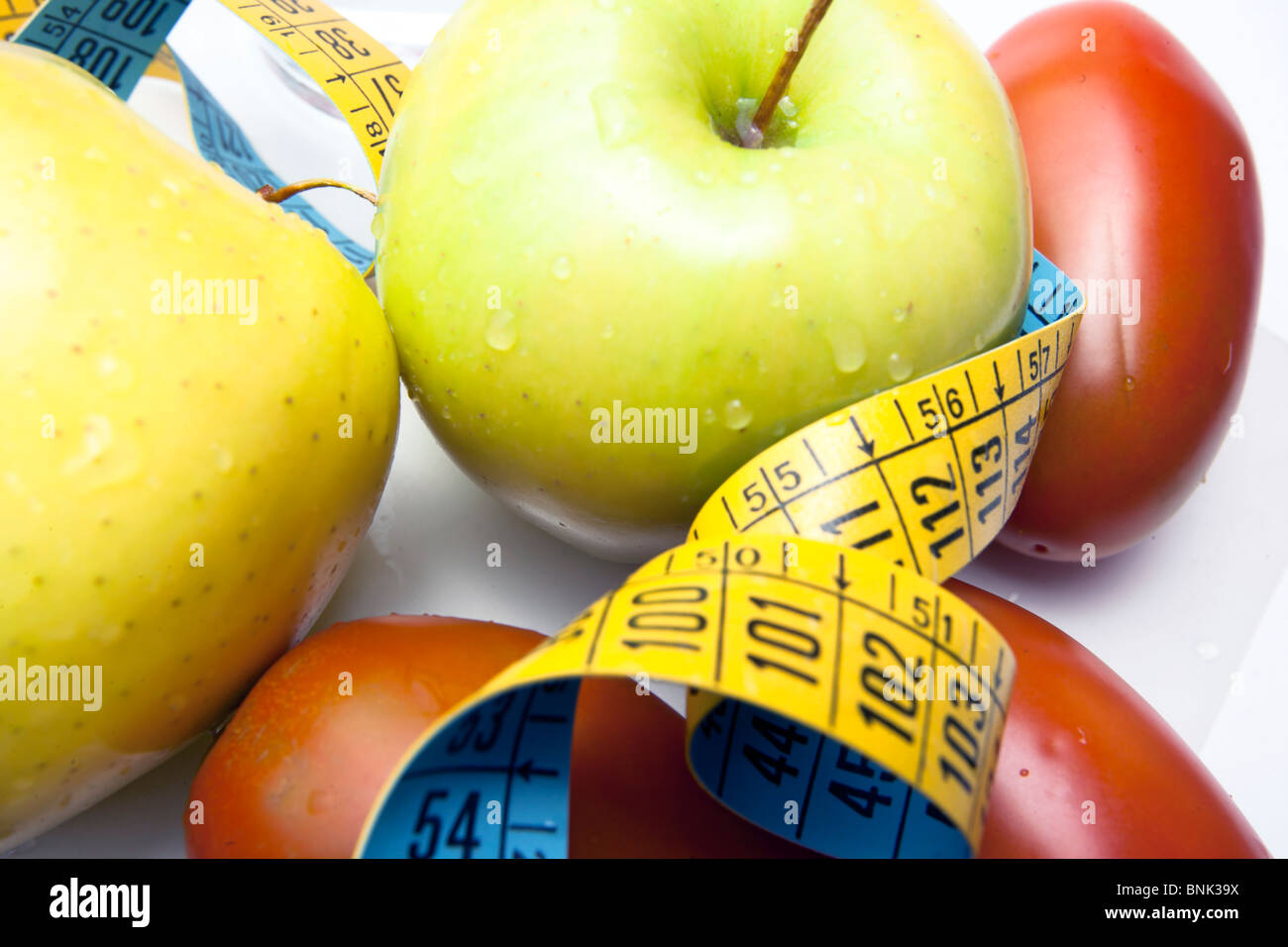 apples and tomatoes with centimeter Stock Photo