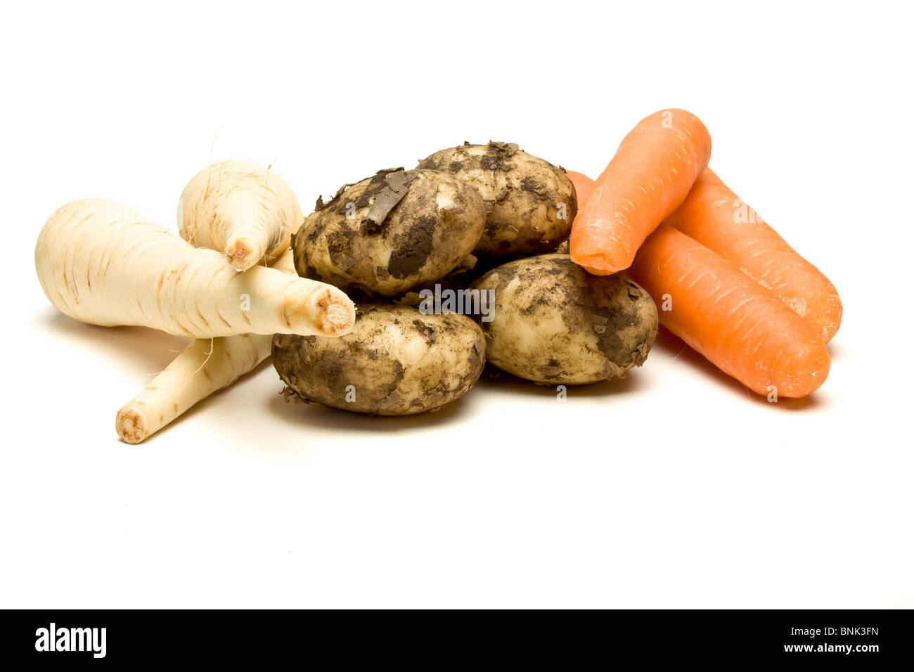 Three root vegetables from low perspective isolated against white background. Stock Photo