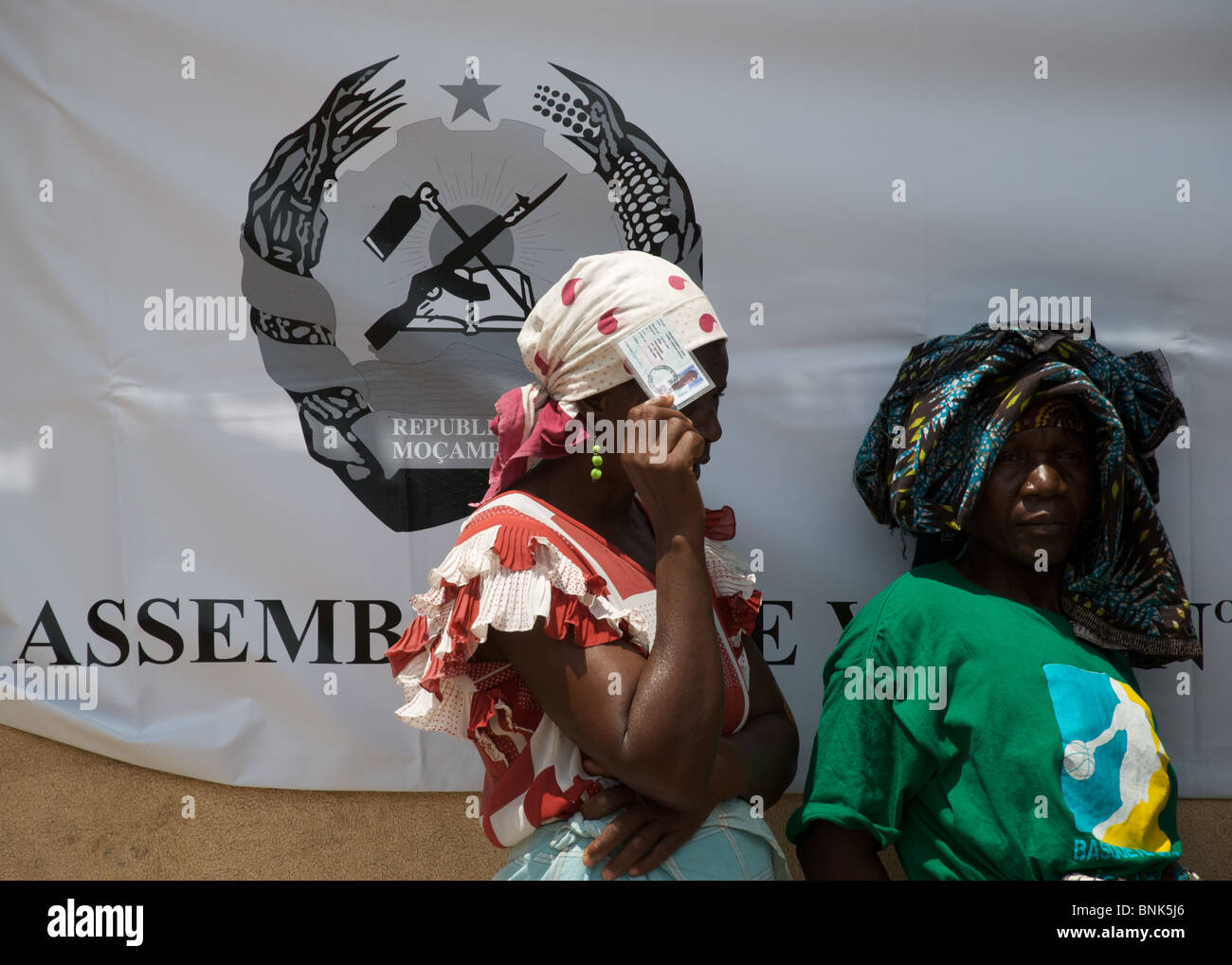Women brandishing their id cards wait in line for their chance to vote in Mozambique's general election in November 2009 Stock Photo