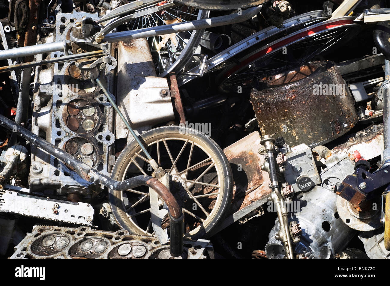 Scrap metal wheels and engines ready for recycling in a scrapyard Stock