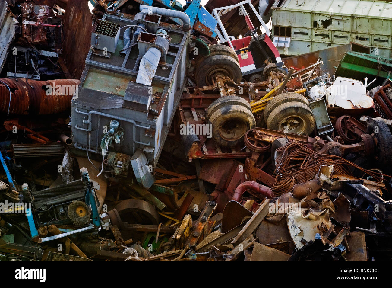 Large scale industrial scrap metal is piled a hundred feet high, ready