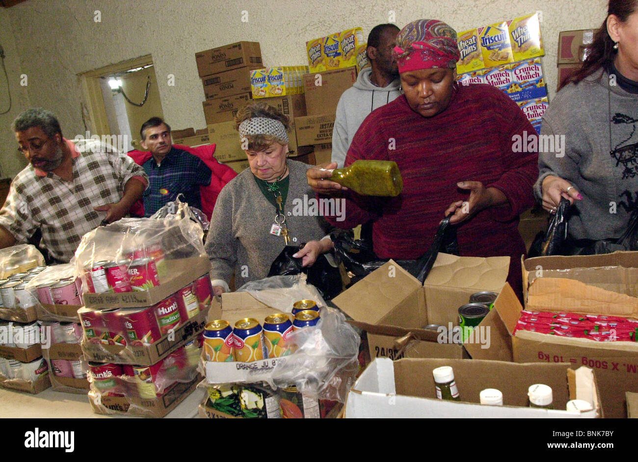 Volunteers pack groceries at the Love Gospel Assembly Church food bank on December 18, 2002 Stock Photo