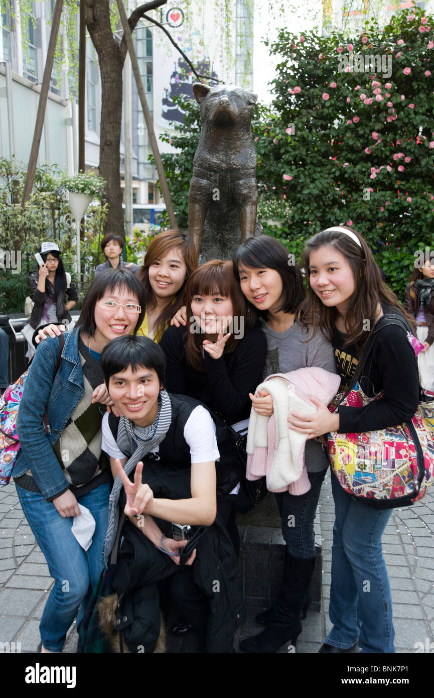 Young people having their photo taken besides the Hachiko dog statue outside Shibuya station, Tokyo, Japan Stock Photo