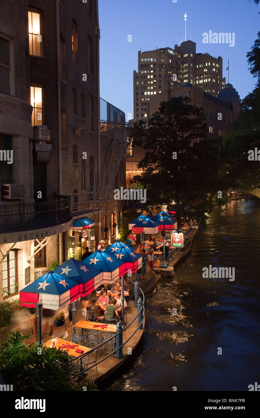 People eating at restaurant on San Antonio River Walk at dusk Texas USA Stock Photo