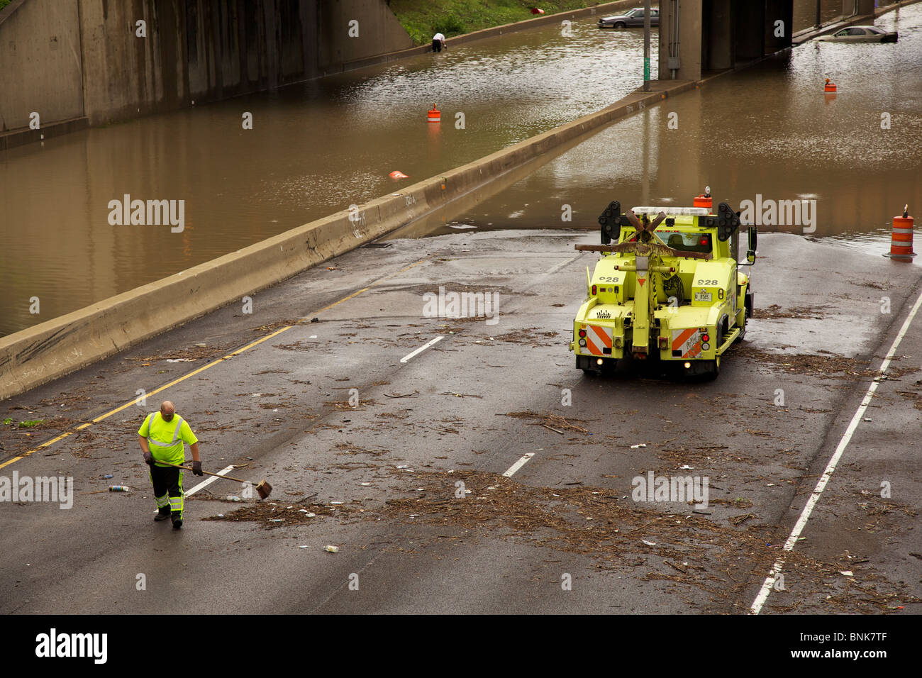 Highway worker clears debris from Insterstate 290 after severe flooding