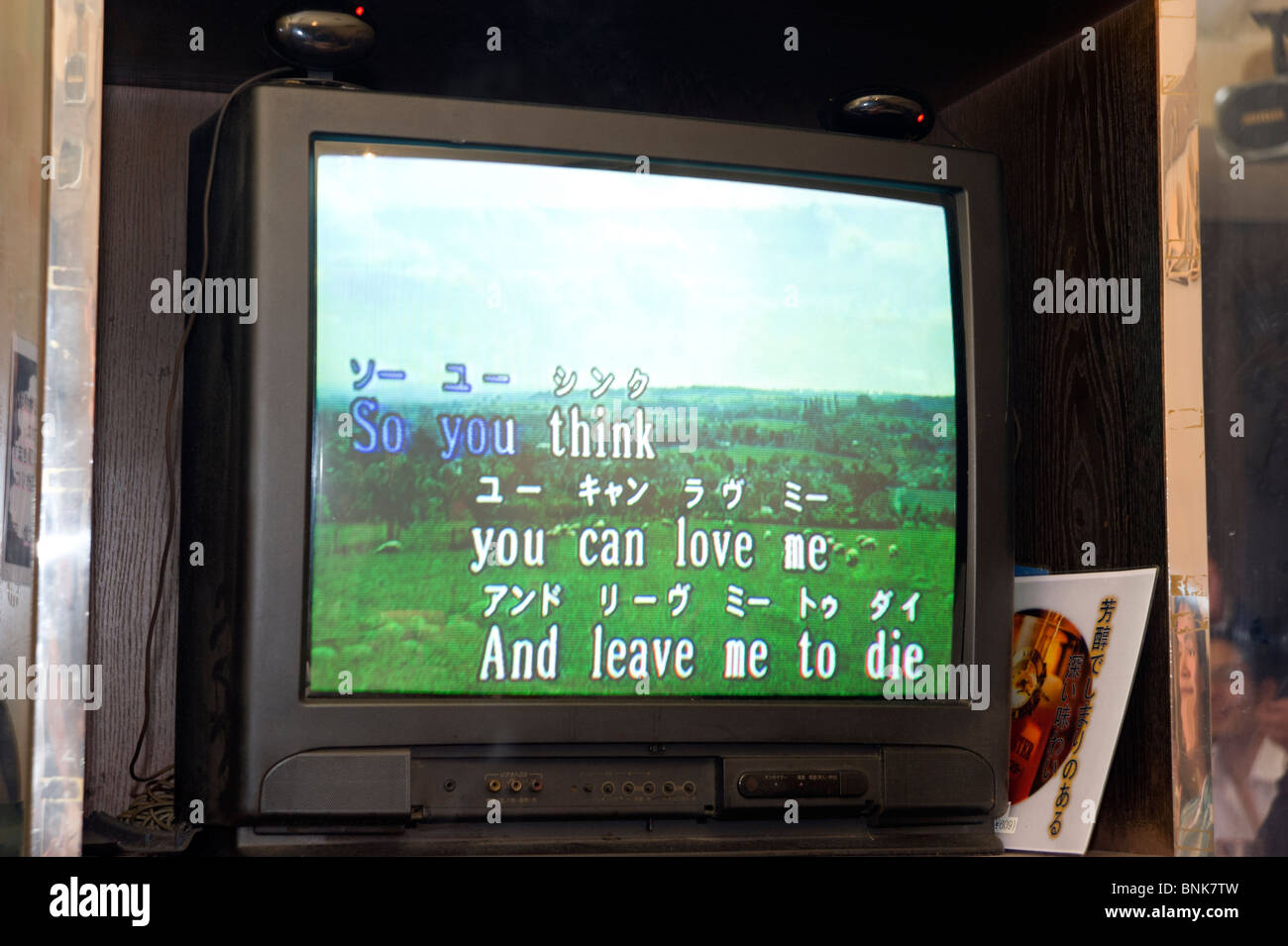 TV screen showing the words of a Queen song in a Japanese karaoke