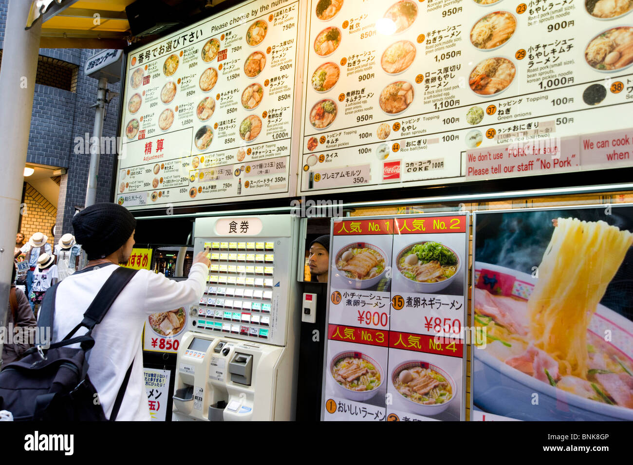Using ticket dispensing machine to order food at cheap ramen and noodle eatery, Tokyo, Japan Stock Photo