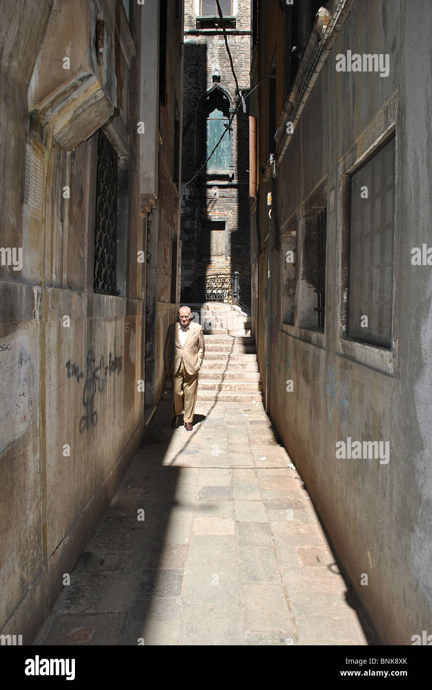 Old man walking down a narrow street in Venice, Italy Stock Photo