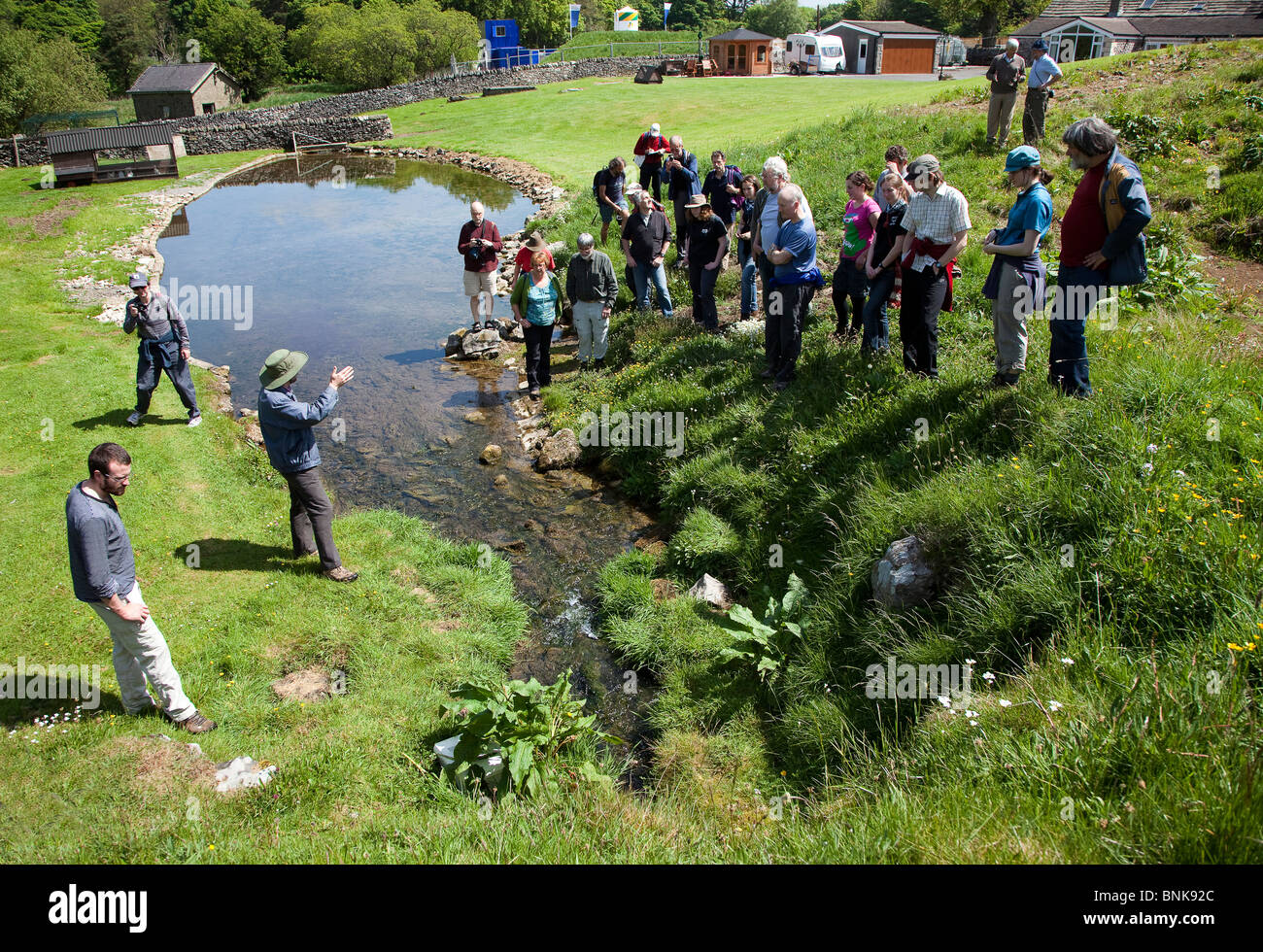 Man talking to science group about hydrology at Otter Hole spring in the Peak District Derbyshire UK Stock Photo
