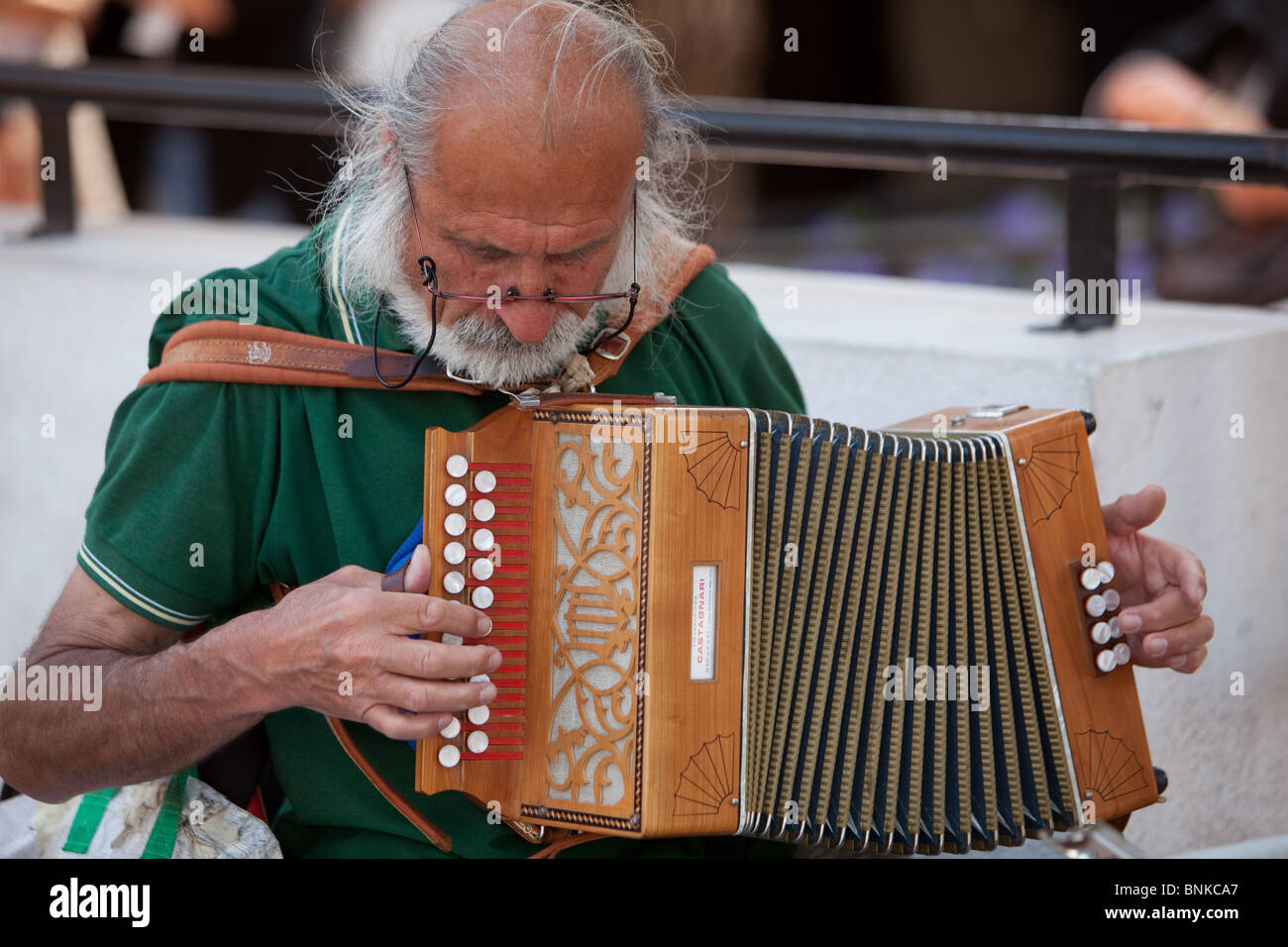 Elderly street busker playing the accordion at Cannes esplanade during the 2010 French film festival Stock Photo