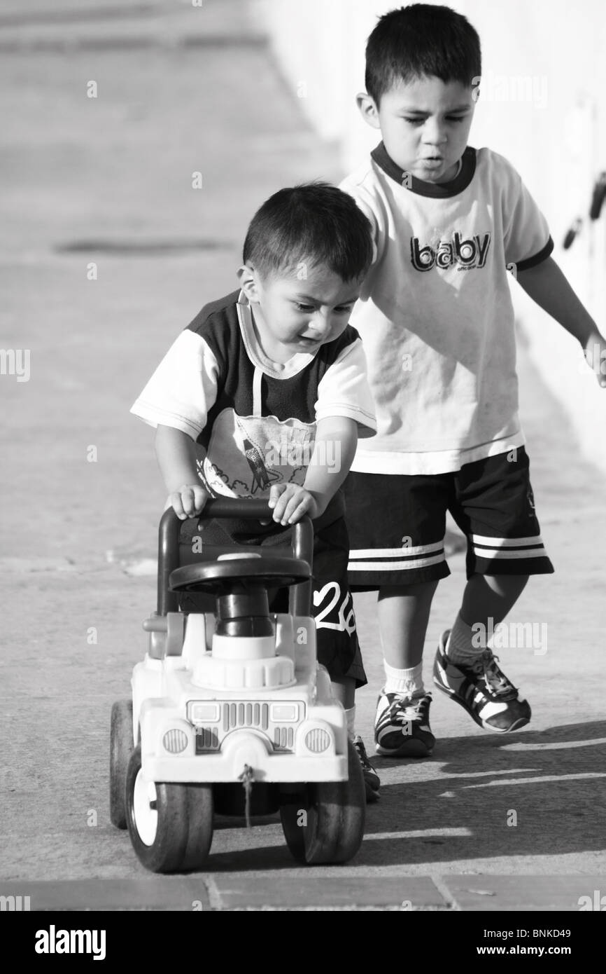 Children playing in the street with a toy-car Stock Photo