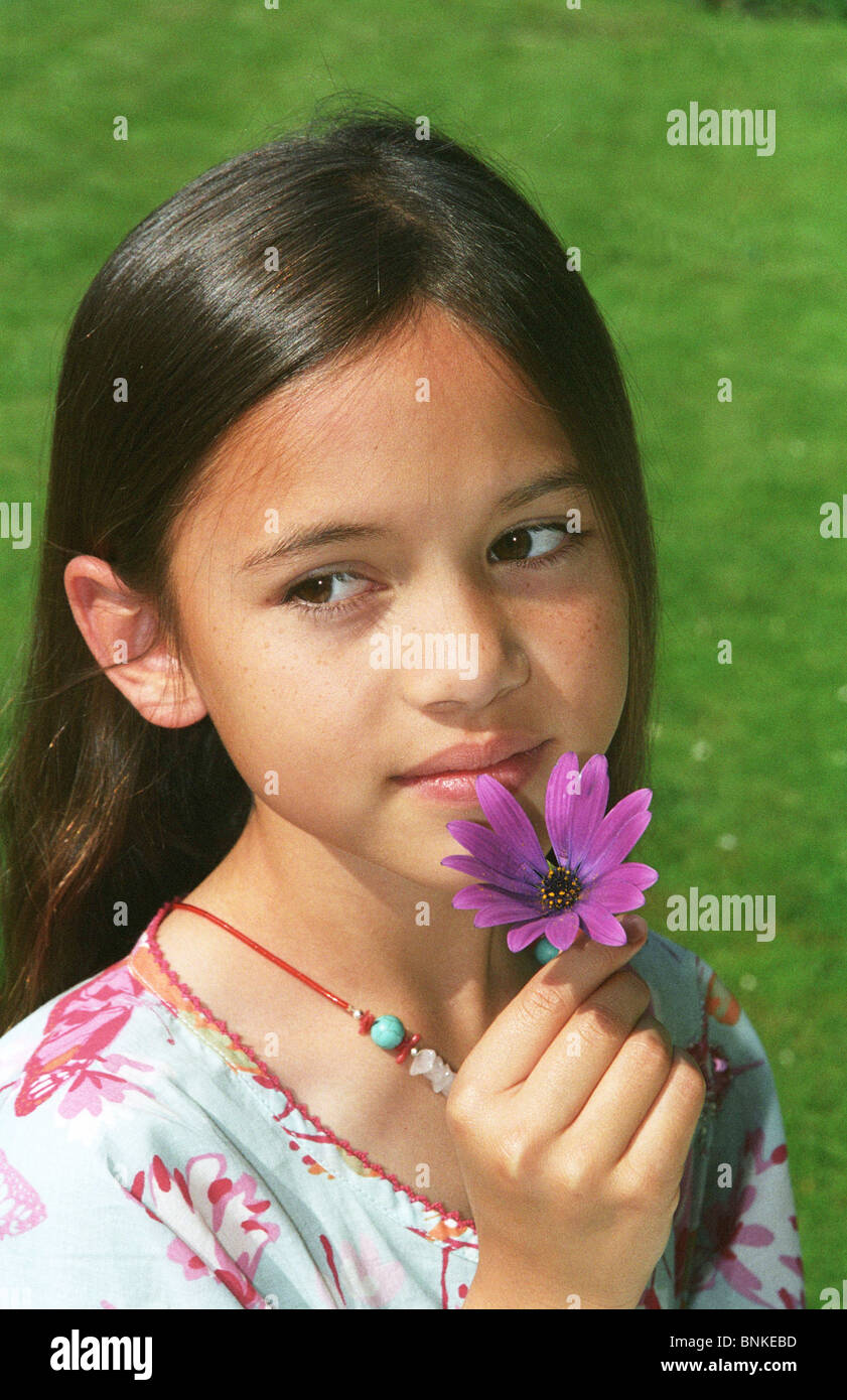 Smiling young girl smelling flower Stock Photo Alamy