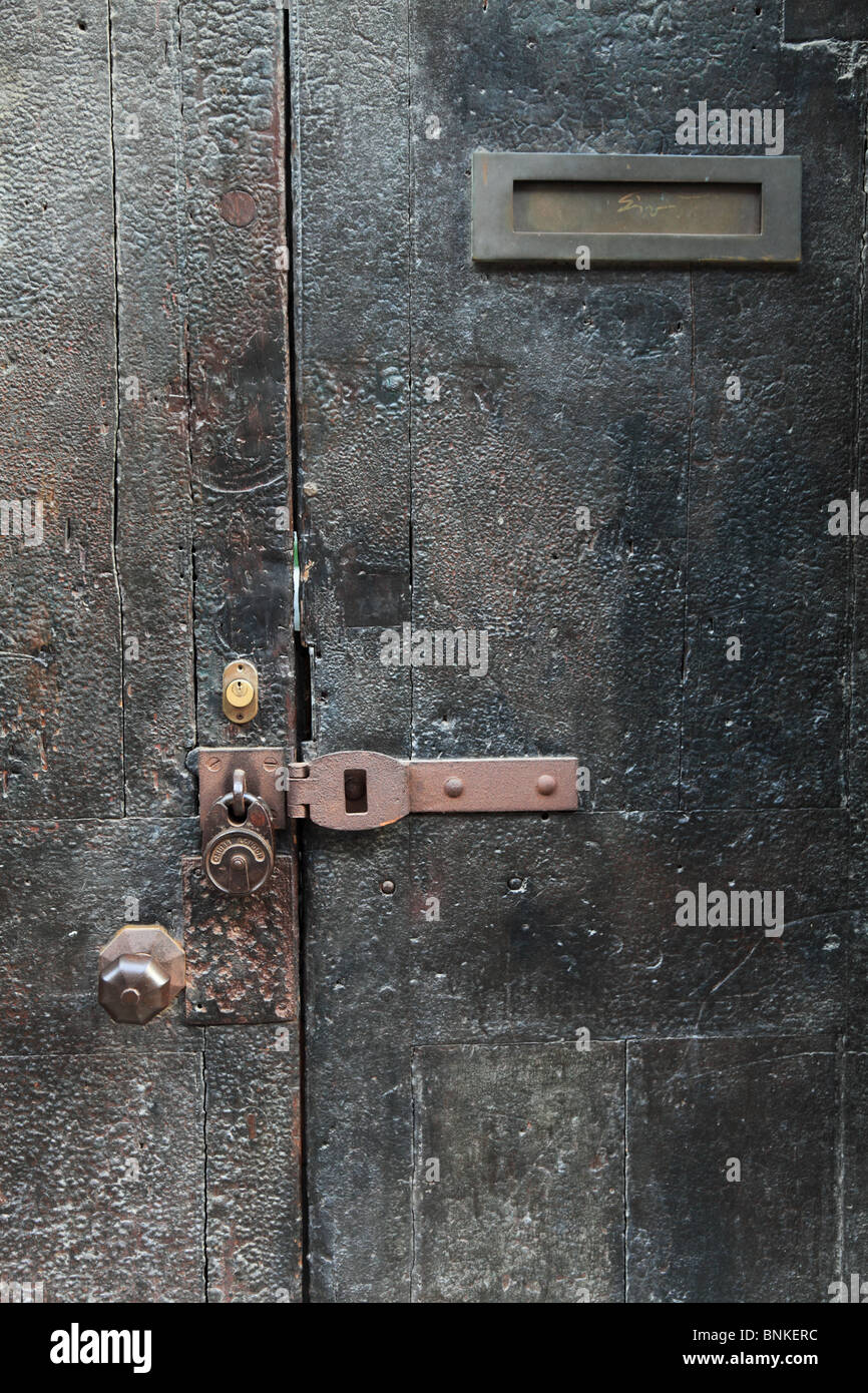 Weathered wooden exterior door. Picture taken from pavement. Stock Photo