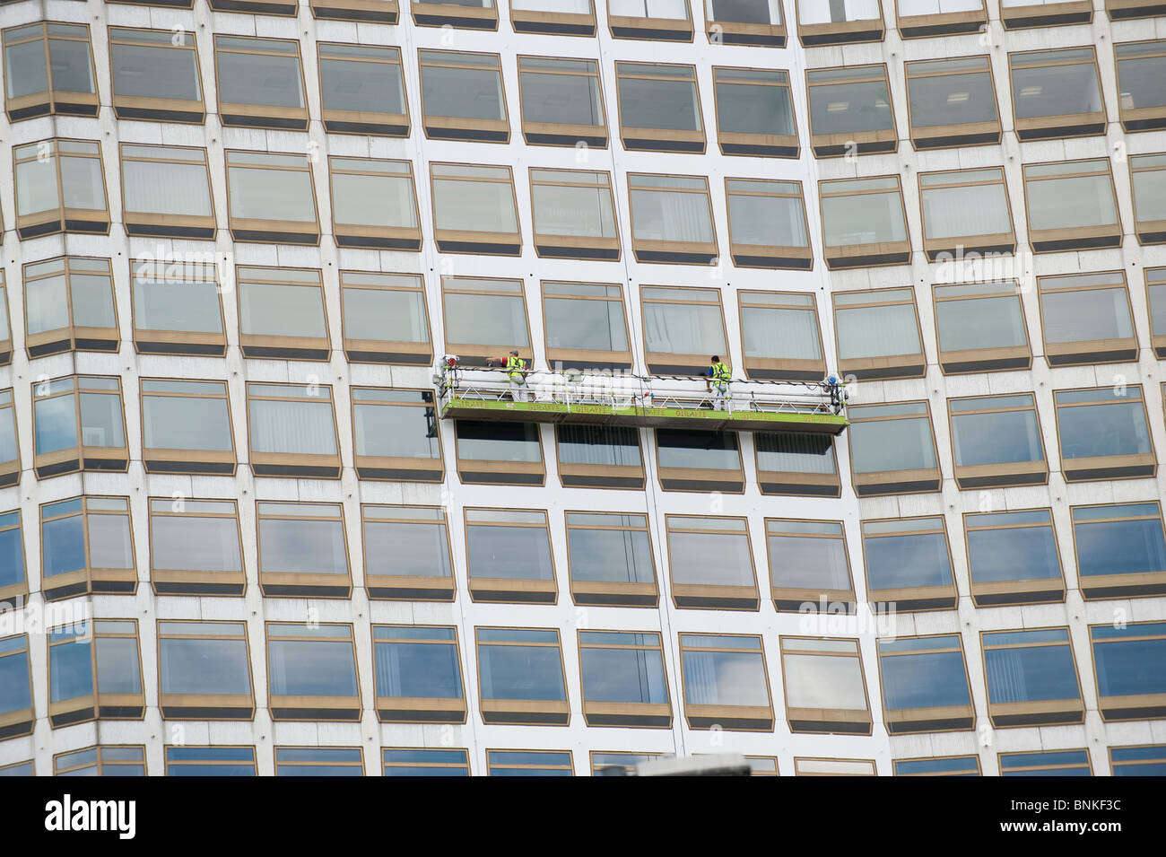 Window cleaners on a gantry clean the glass of a City Centre office