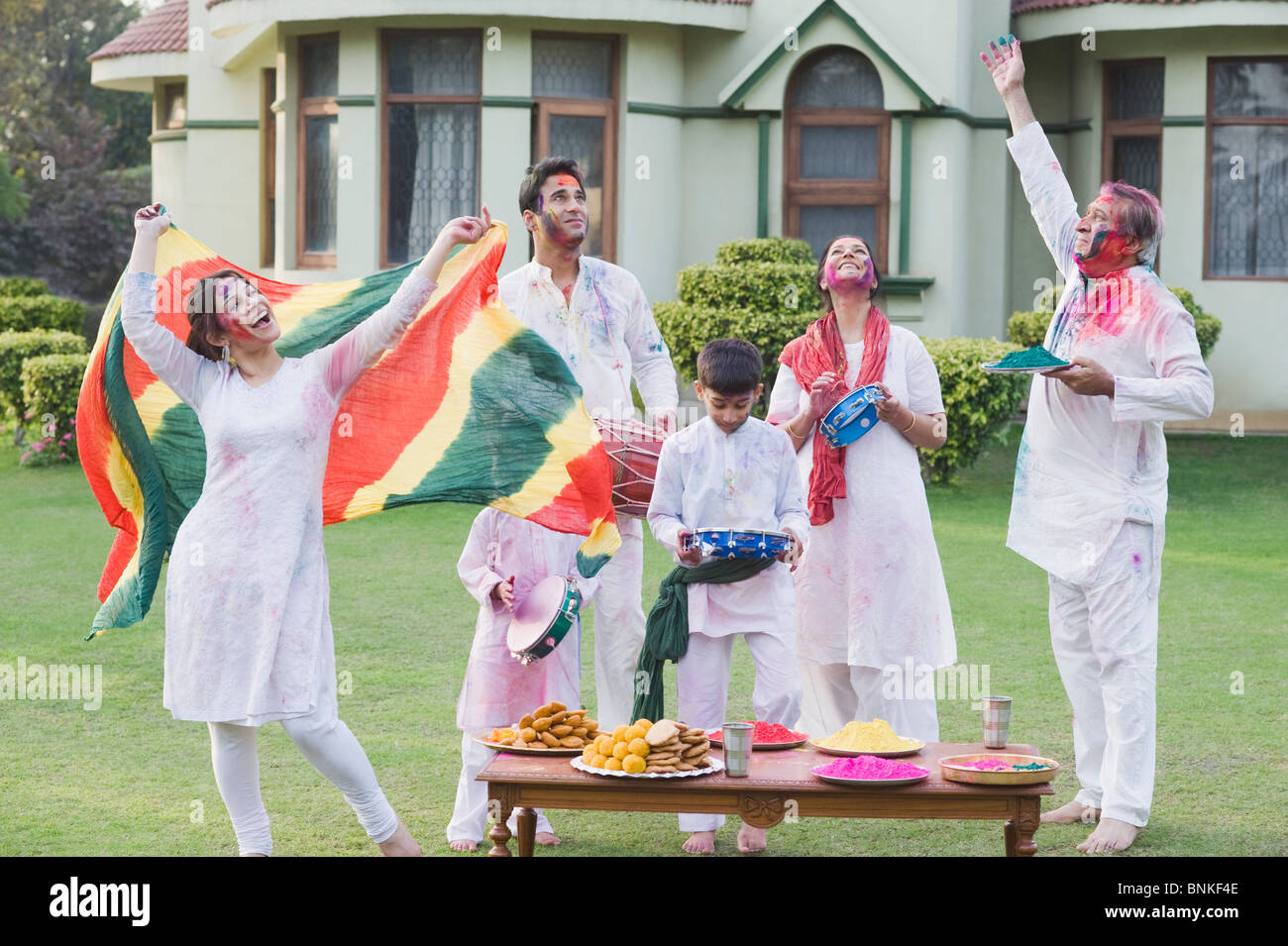 Family dancing and celebrating Holi Stock Photo