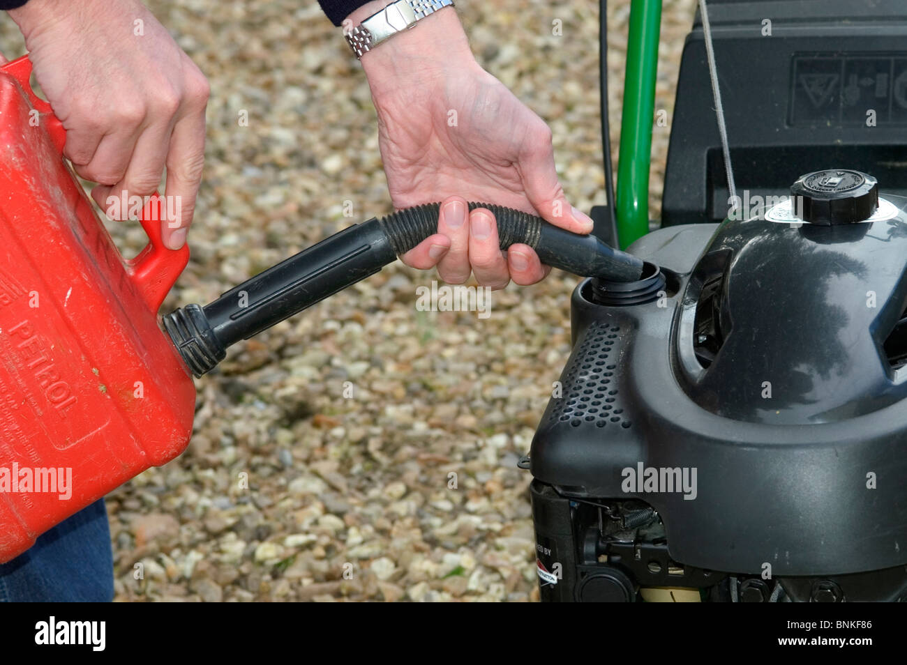 Filling petrol tank on petrol driven rotary mower Stock Photo