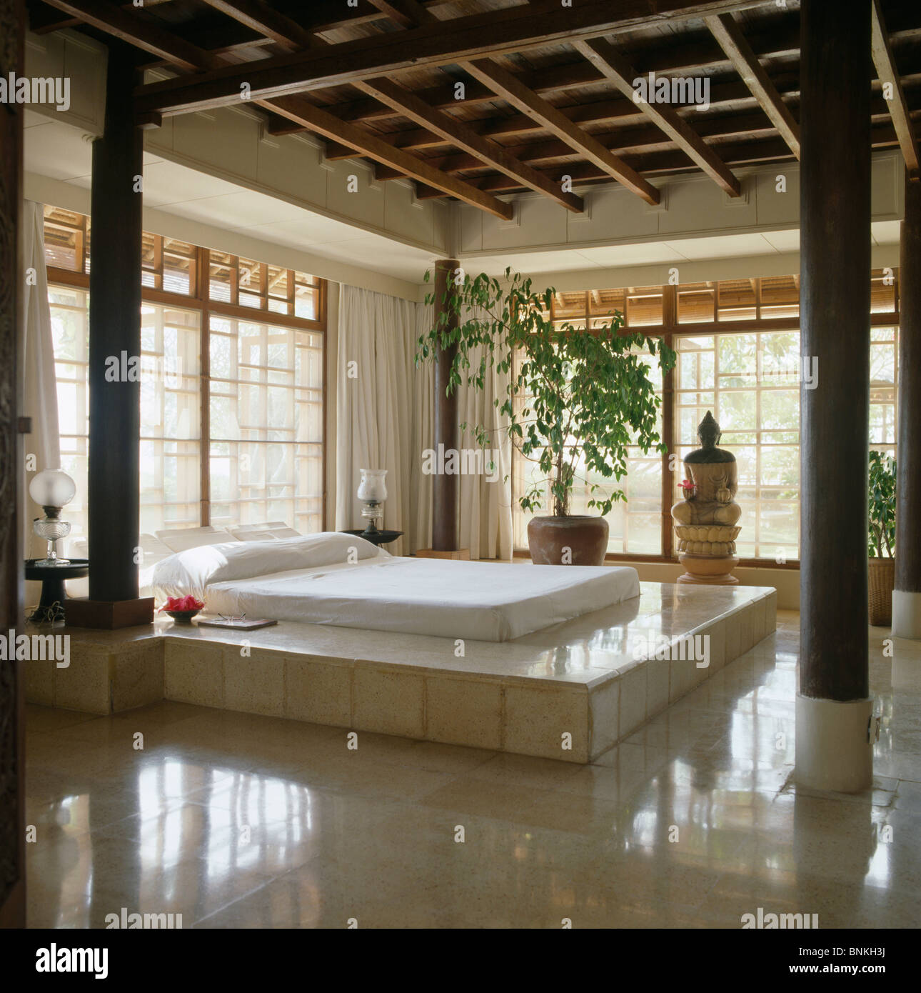 White Pillow And Bed Cover On White Tiled Raised Bed In