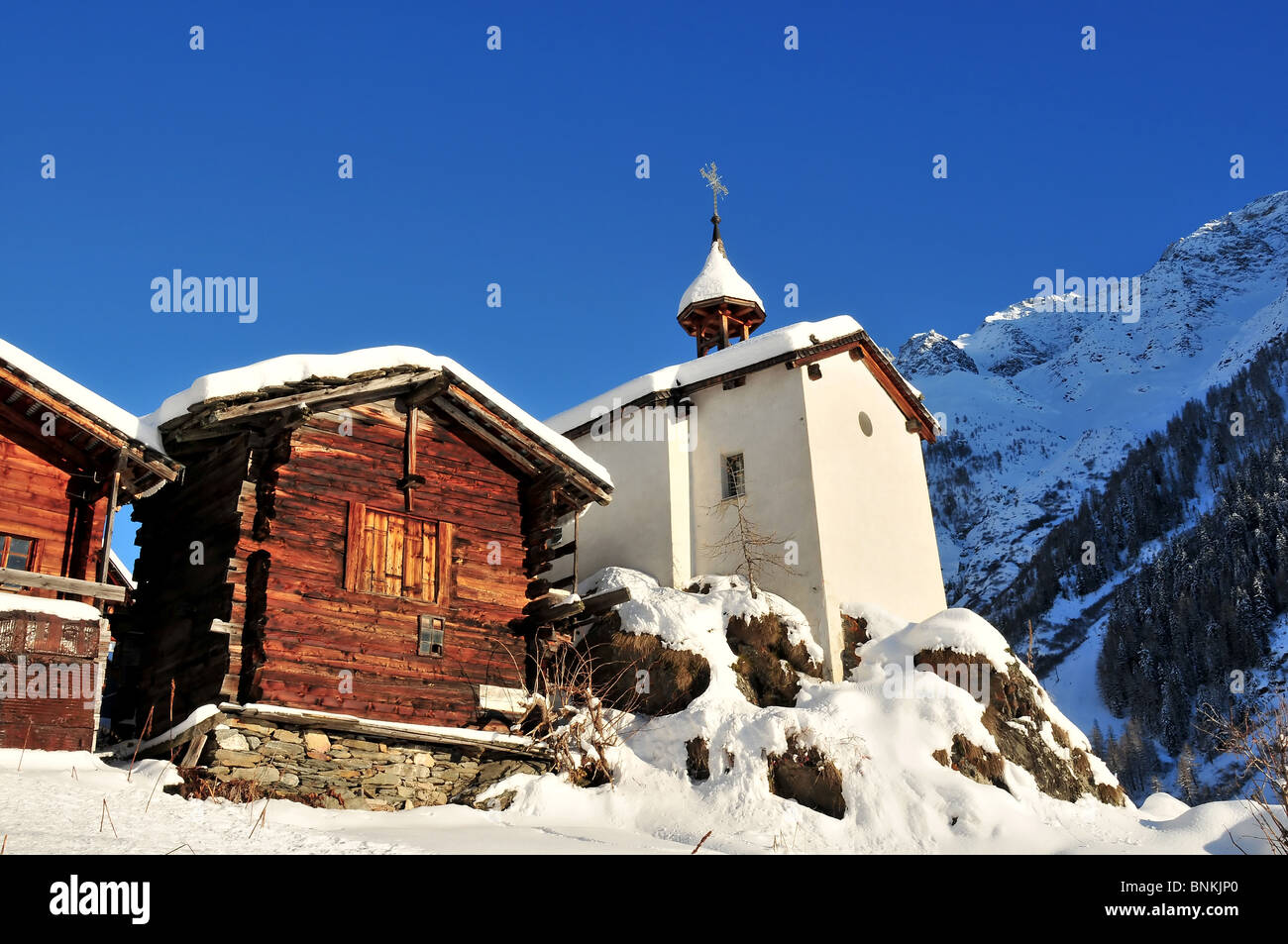 Switzerland Valais Blatter building construction chalet hut wood wood forest mountain Alps church Swiss snow chapel village Stock Photo