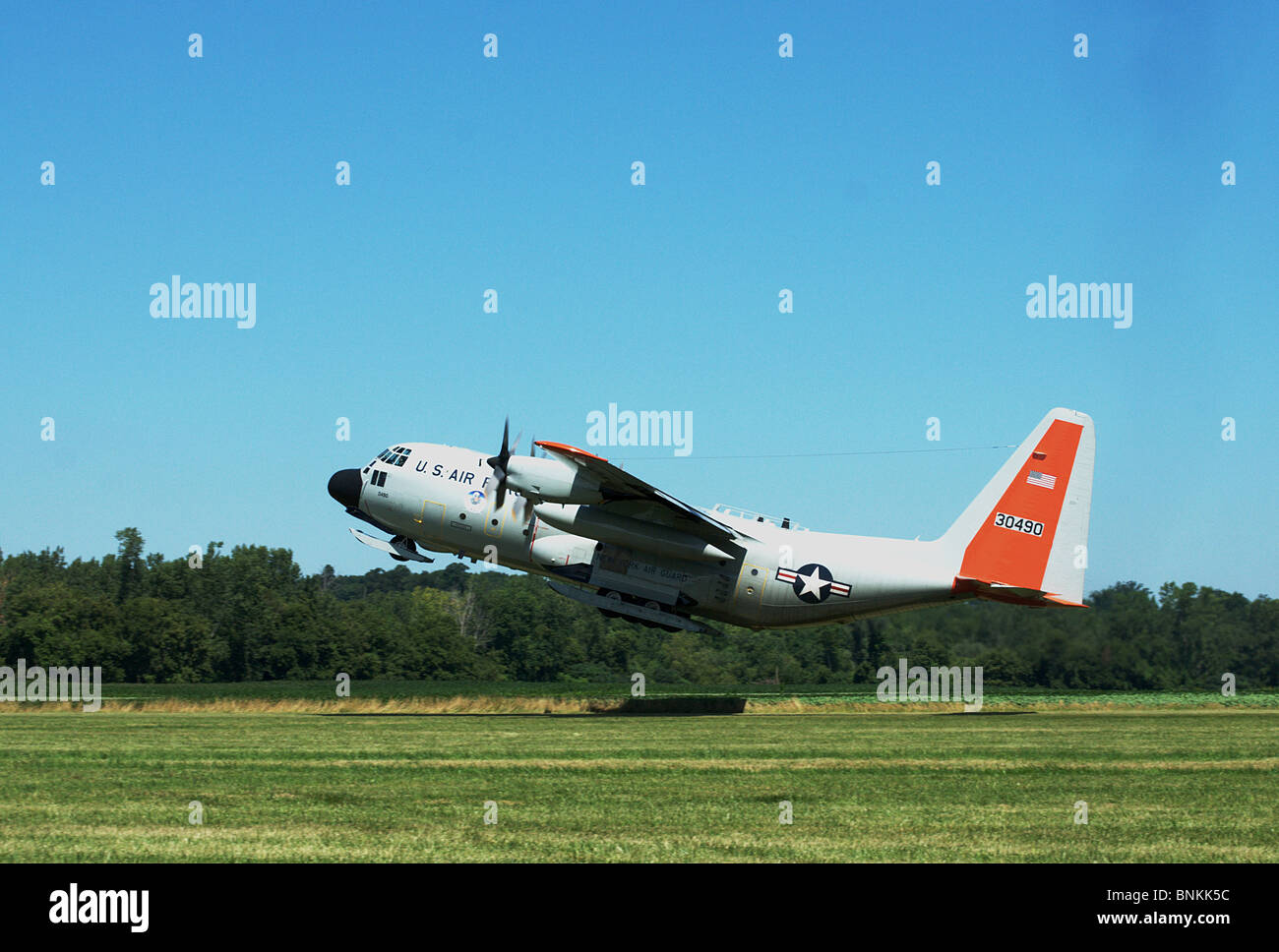 C-130 Hercules takes off from Geneseo Air Show grass runway with skids. Stock Photo