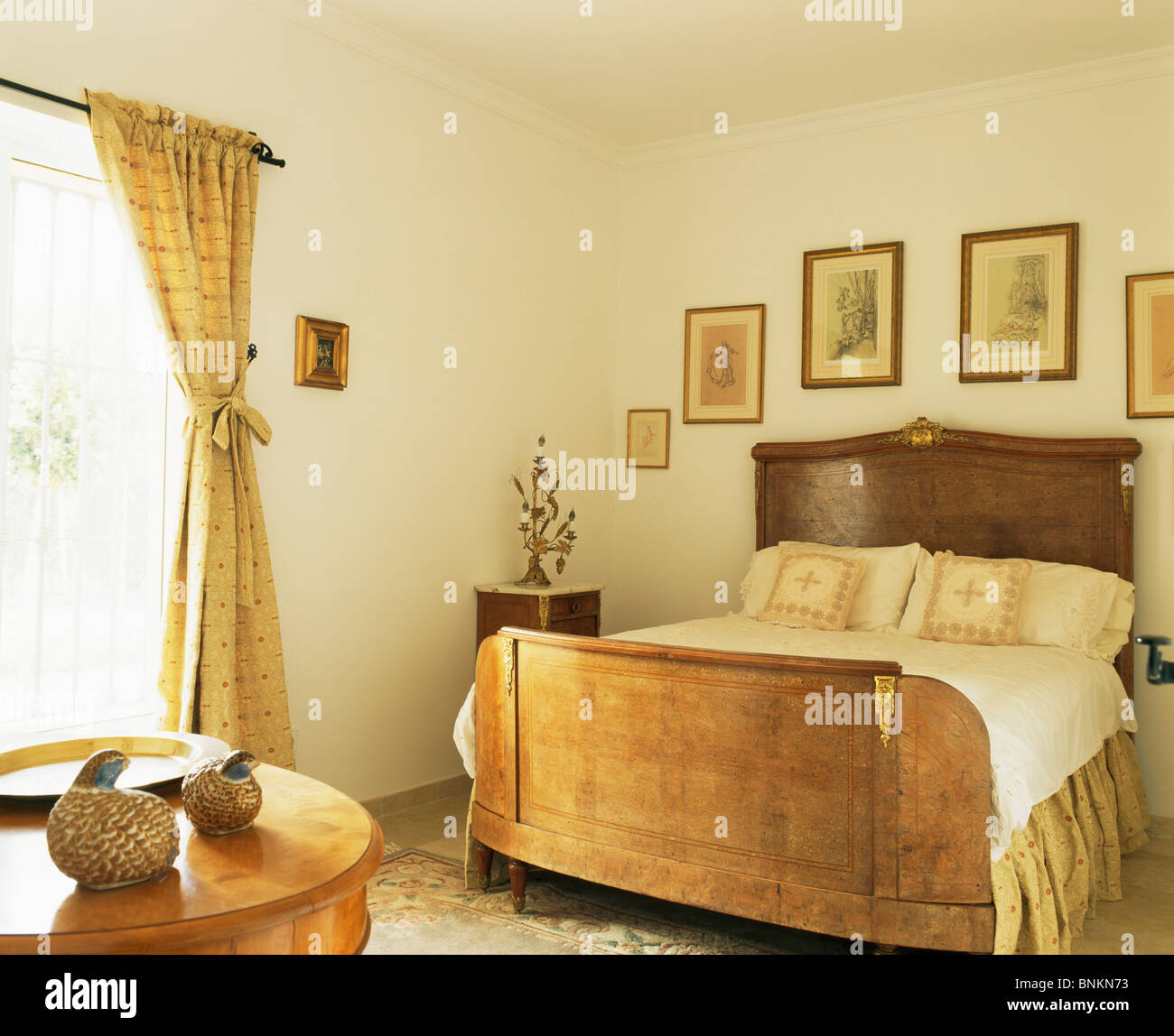 Pictures On The Wall Above Antique Mahogany Bed In Cream