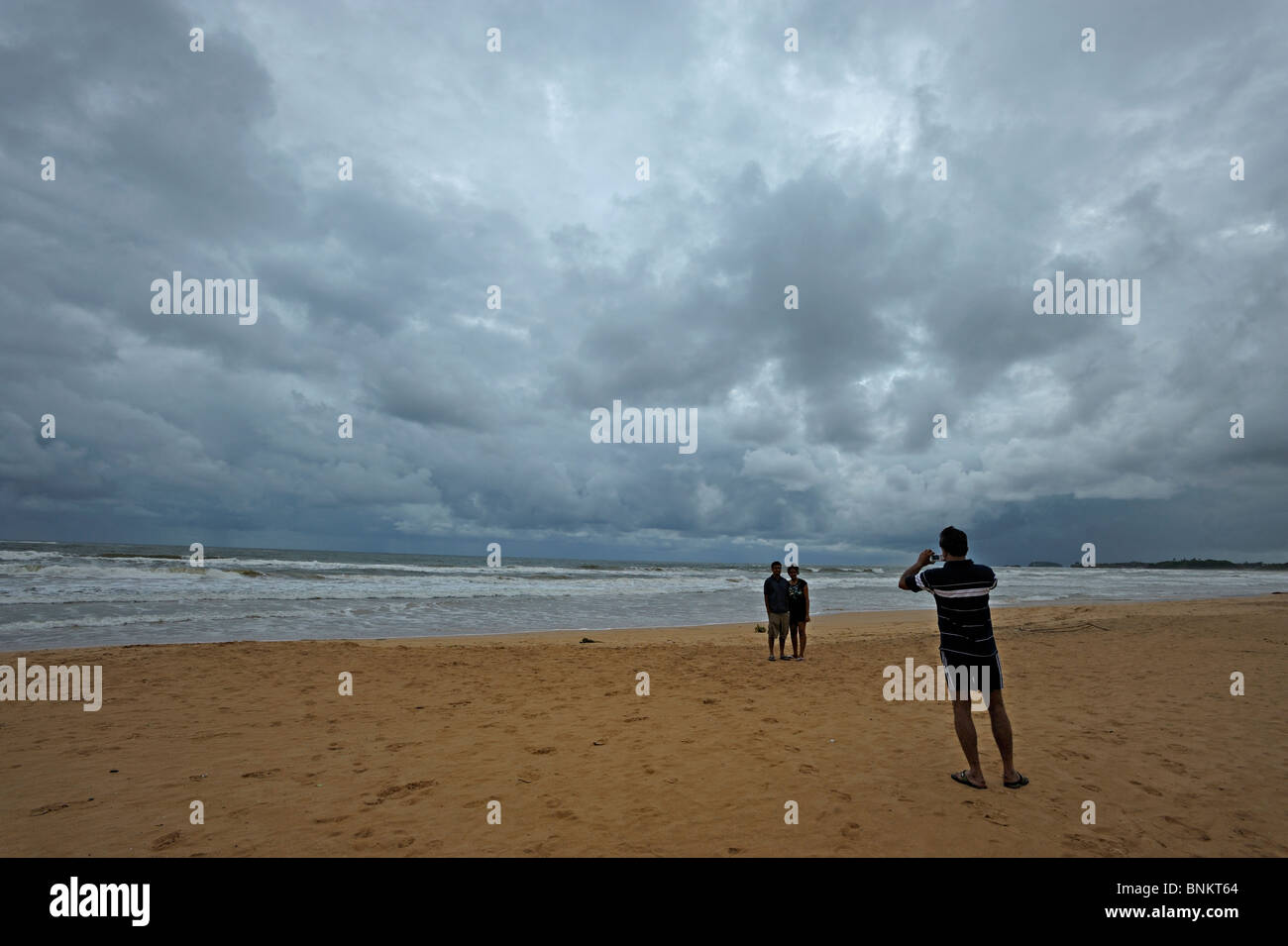 Tourists taking snap shots of each other in Bentota beach in Sri Lanka Stock Photo