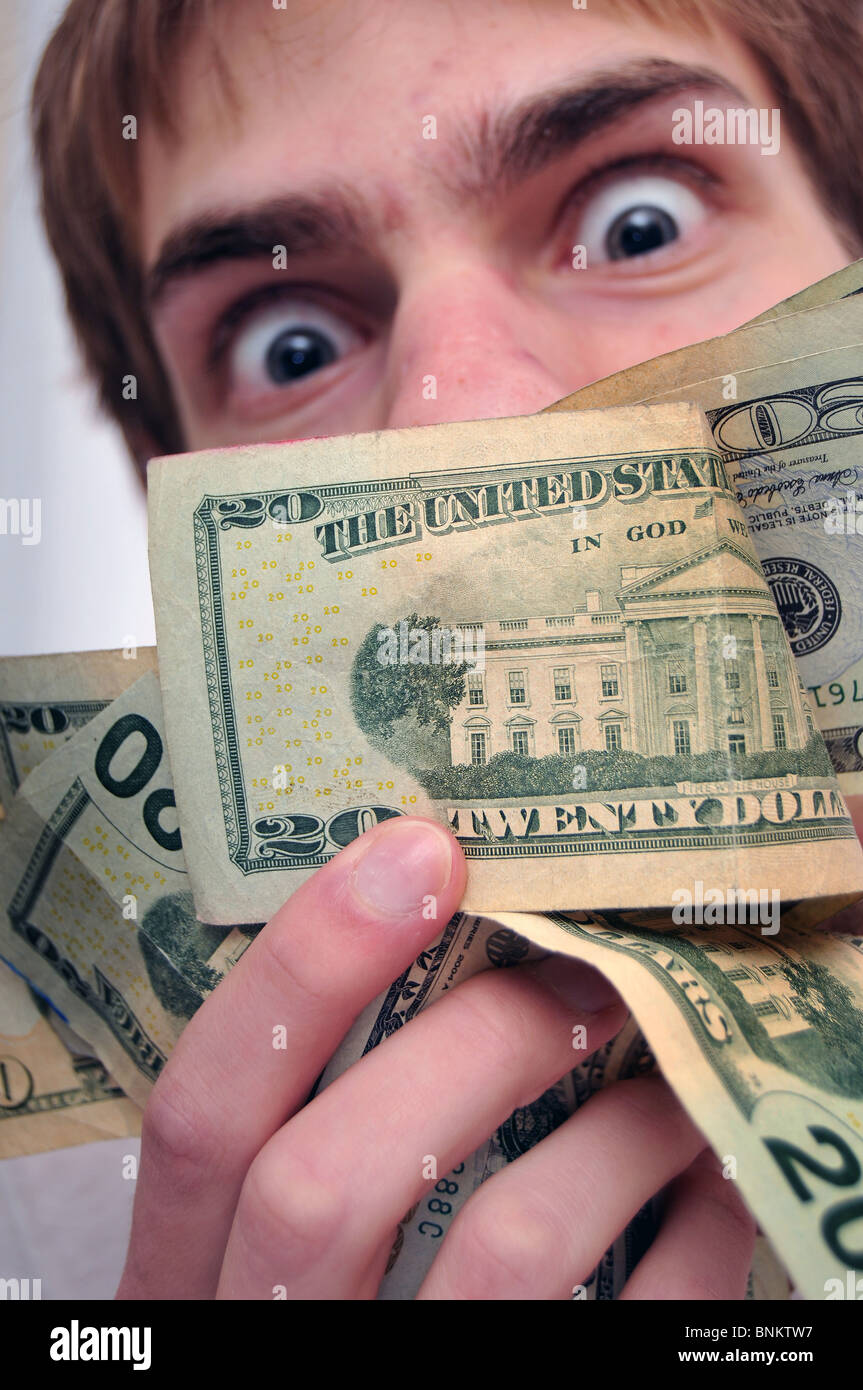 Blurred Man in background staring at a wad of cash, with an intentional slightly dramatic blue tint. Stock Photo