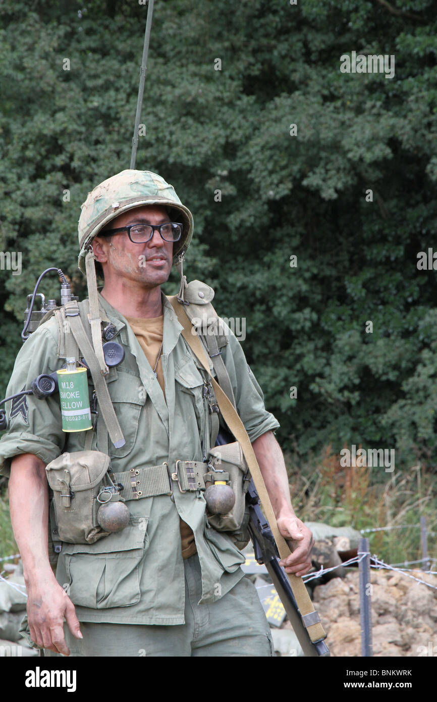 A re-enactment of the Vietnam conflict. A soldier dressed in full military  uniform carrying a radio, gun at his side Stock Photo - Alamy