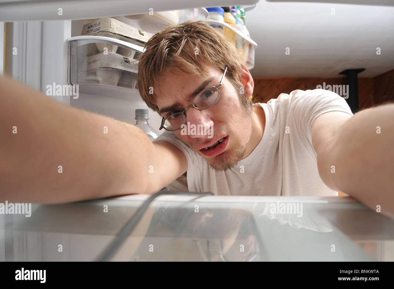 Nerdy Man looking for food in refrigerator Stock Photo
