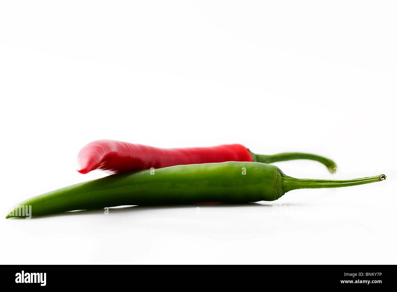 one red and a green chili isolated on white background Stock Photo - Alamy