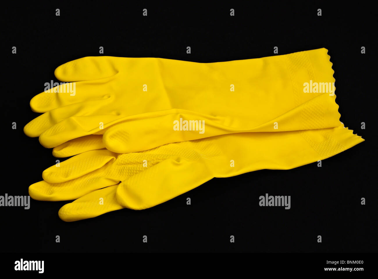 Pair of household yellow latex gloves isolated on black Stock Photo