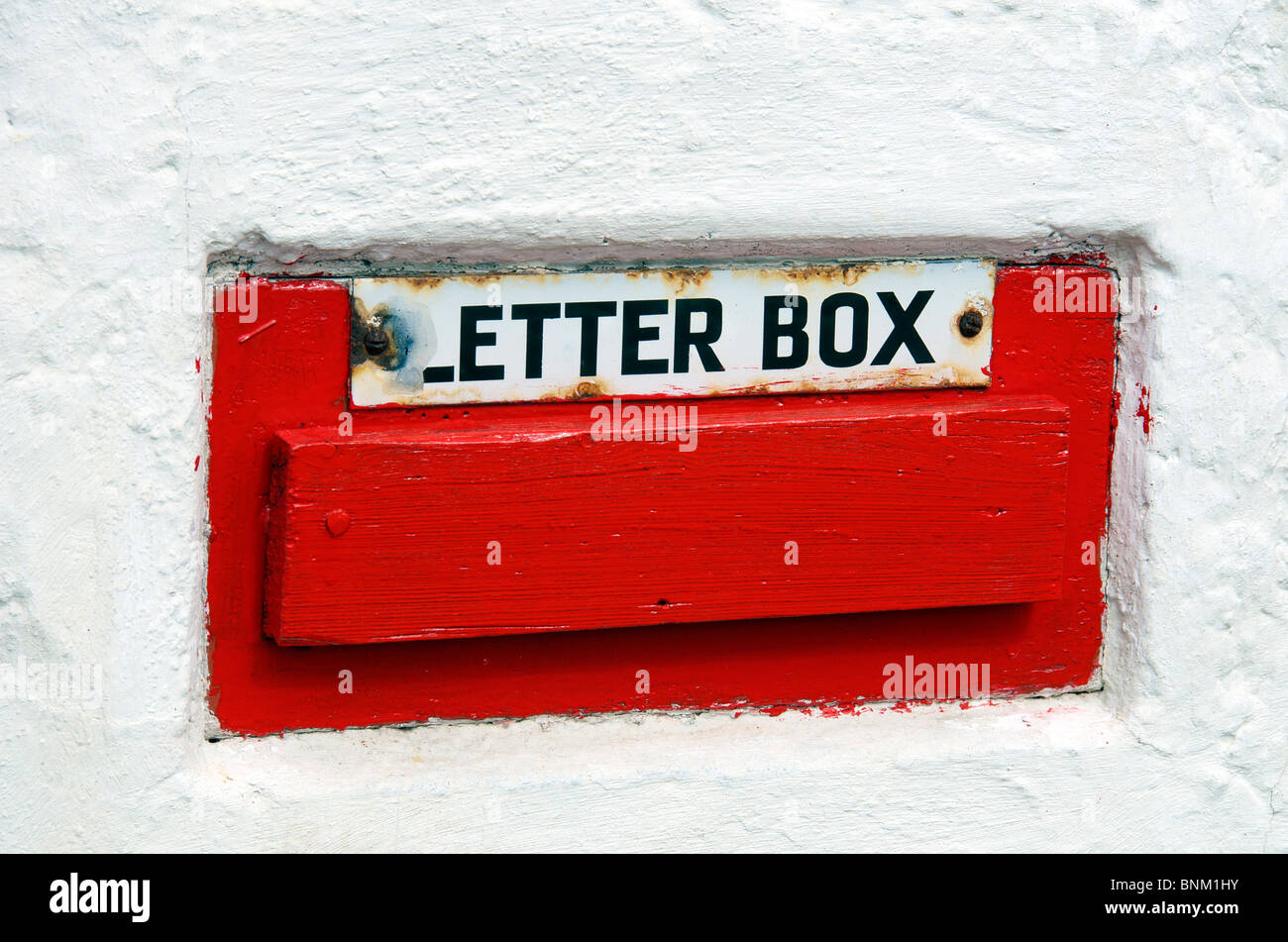 Red letterbox on white wall Plocton Wester Ross, Ross and Cromarty Scottish Highlands North West Scotland Stock Photo