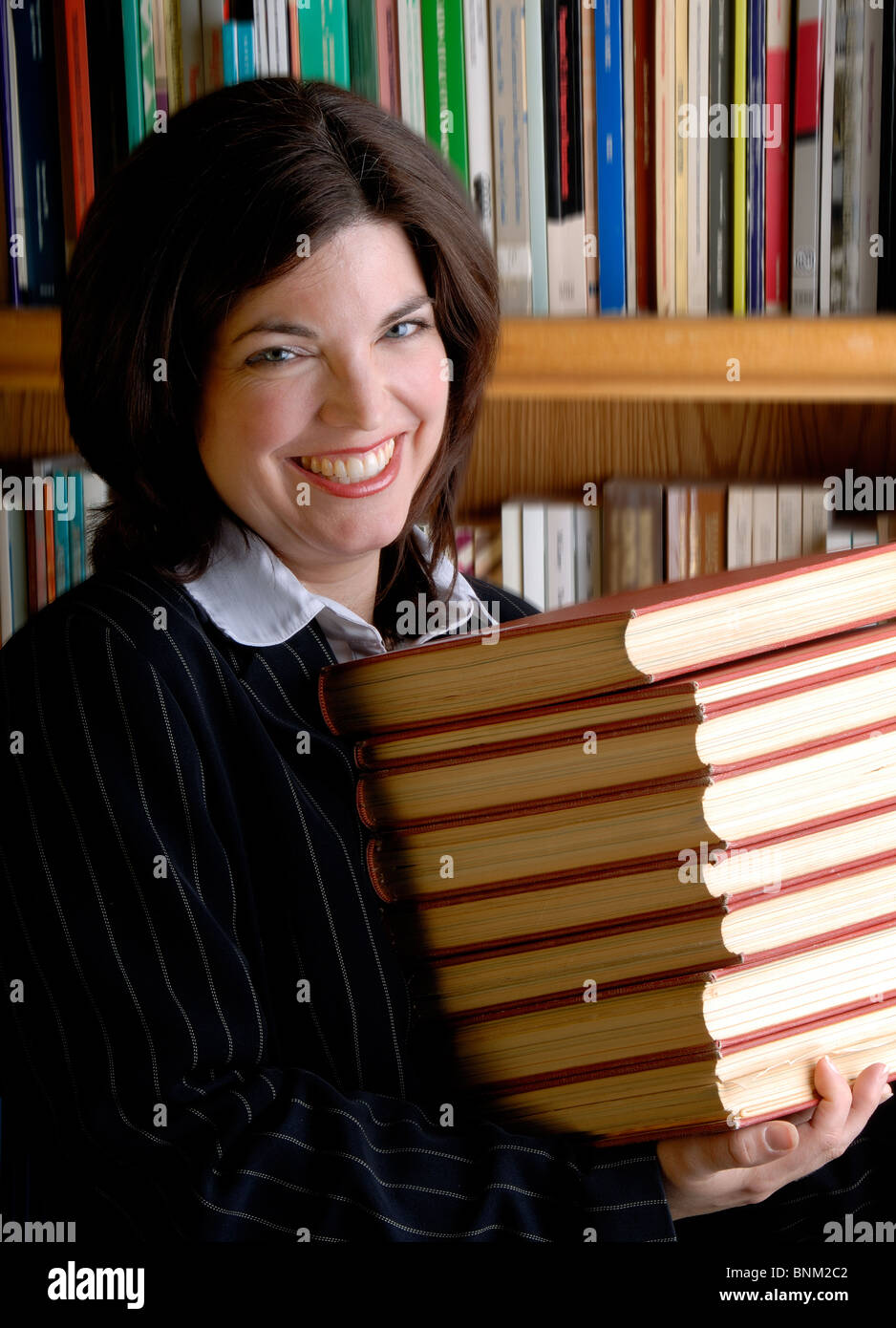 Young Female Lawyer Carrying Legal Text Books In A Library Stock Photo