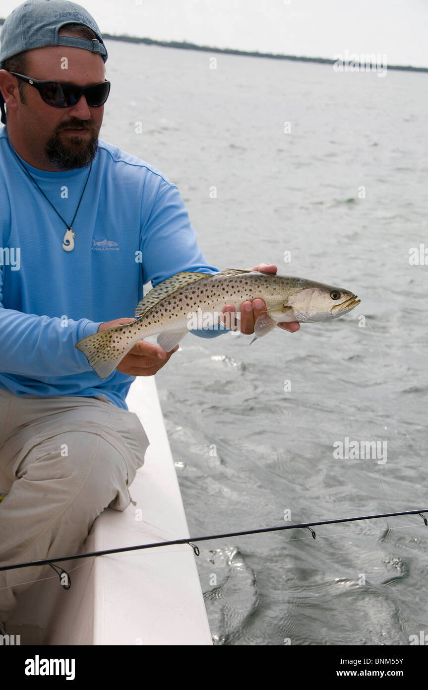 An inshore angler lifts a nice size trout caught in Florida's