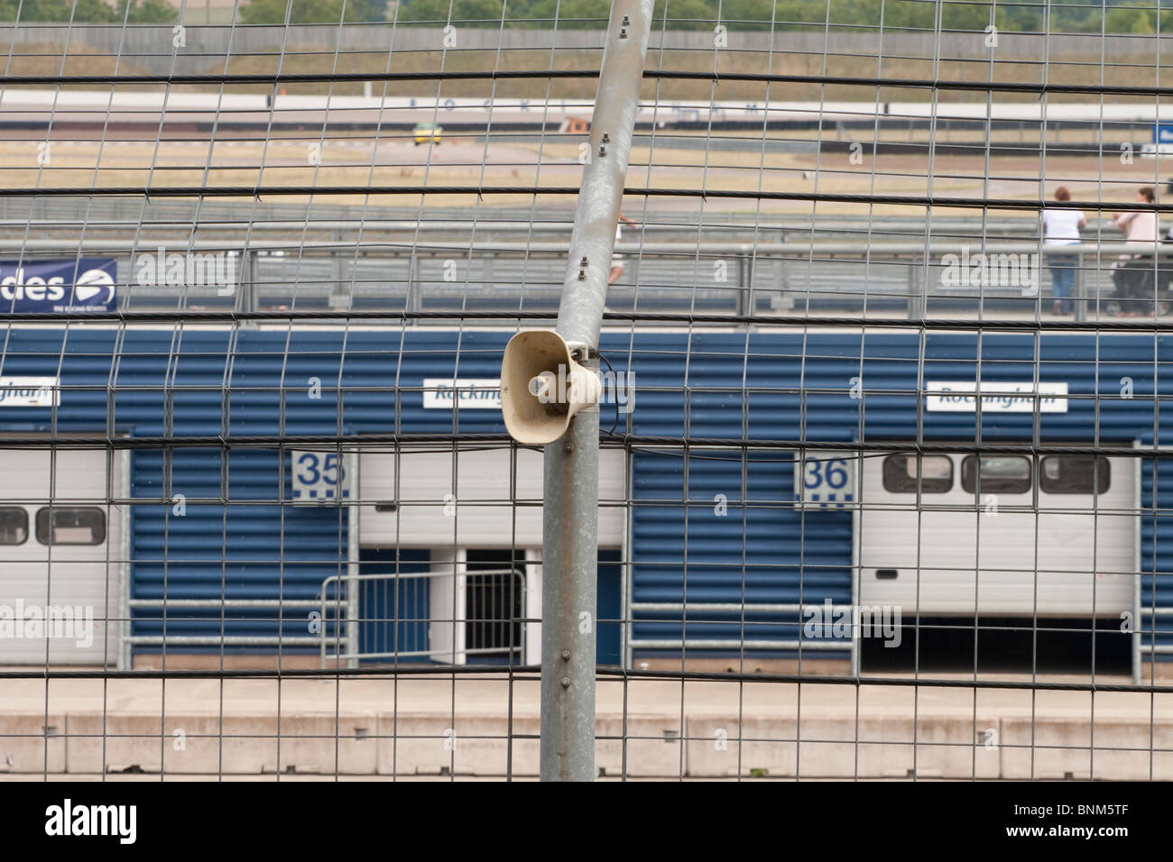 A Tannoy speaker mounted on a fence at a race circuit Stock Photo