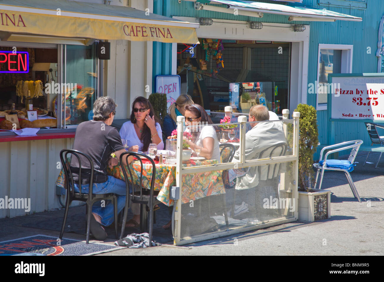 People dining outdoors on Historic Fishermans Wharf shopping and restaurant area in Monterey California Stock Photo