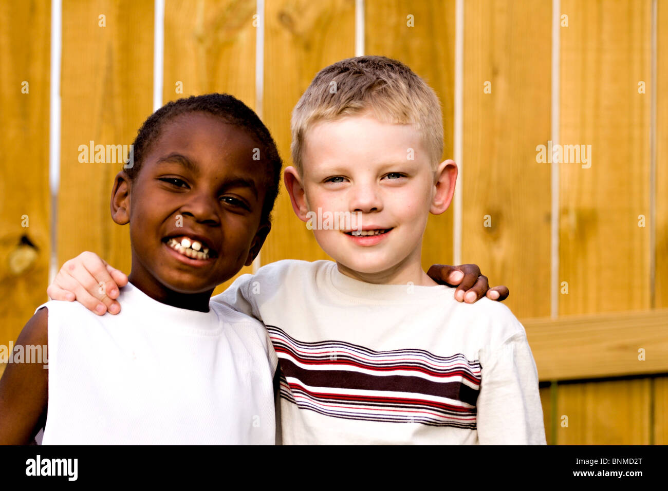 Two young boys posing for the camera with there arms around each other ...