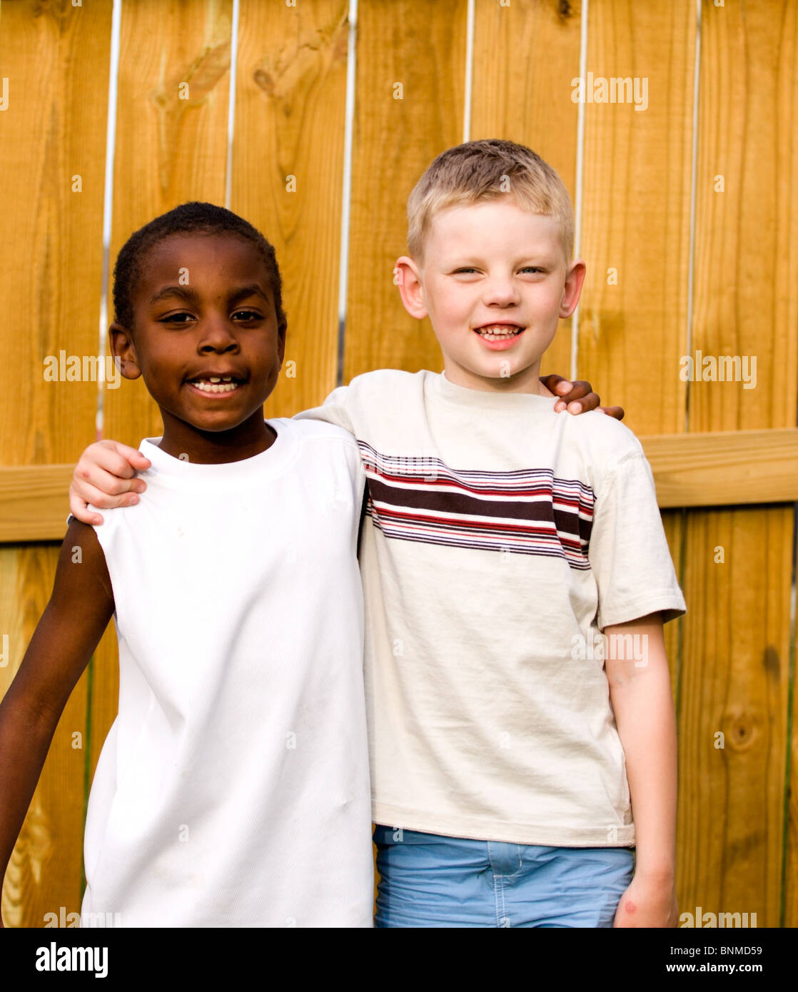 Two young boys posing for the camera with there arms around each other ...